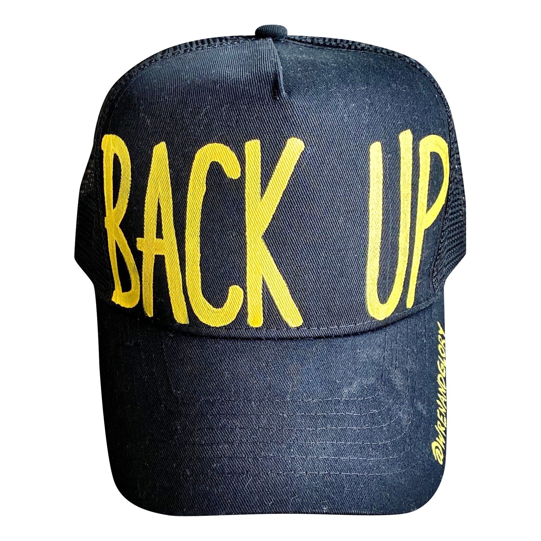 Black lack trucker hat with BACK UP painted on hat in yellow. Signed @wrenandglory