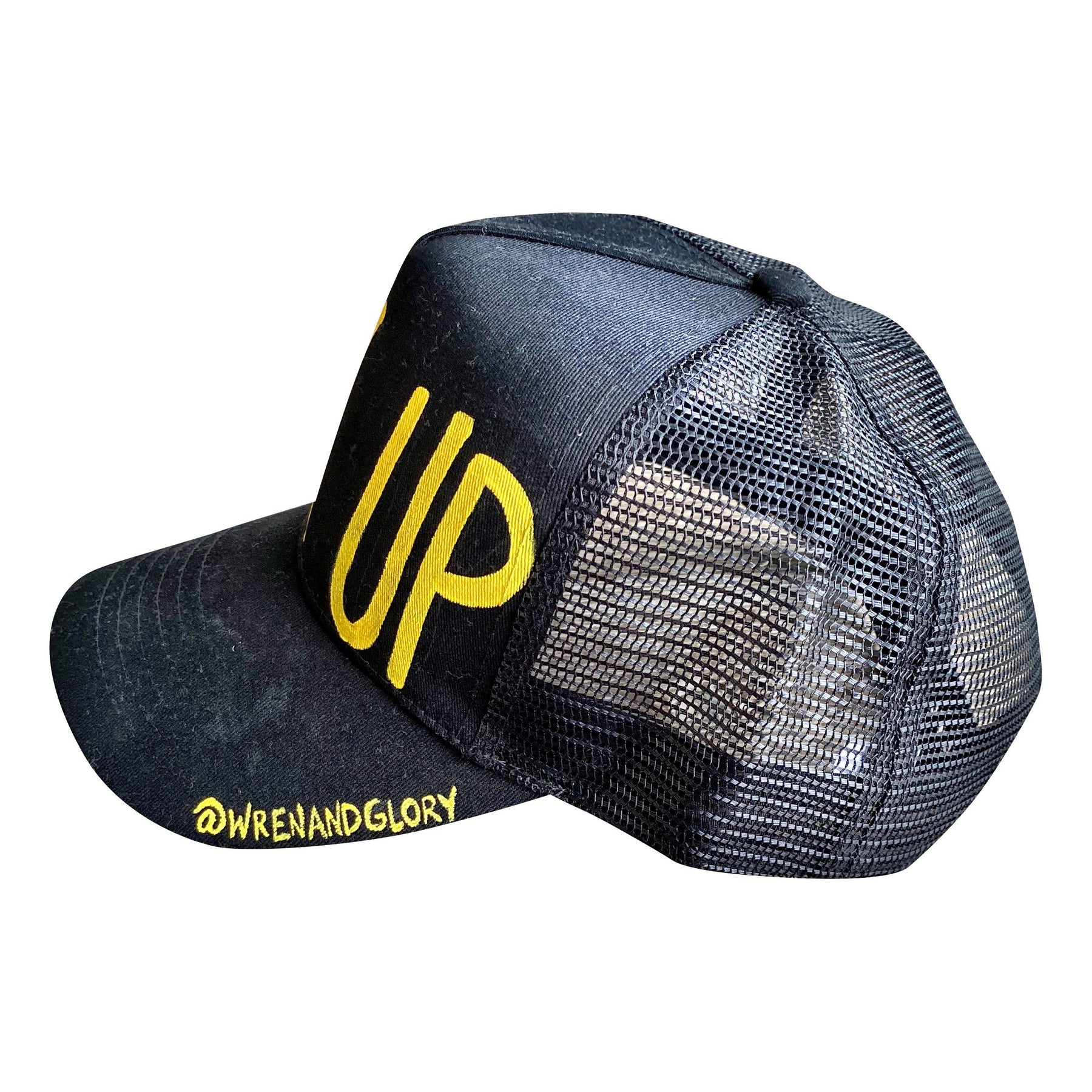 Black lack trucker hat with BACK UP painted on hat in yellow. Signed @wrenandglory