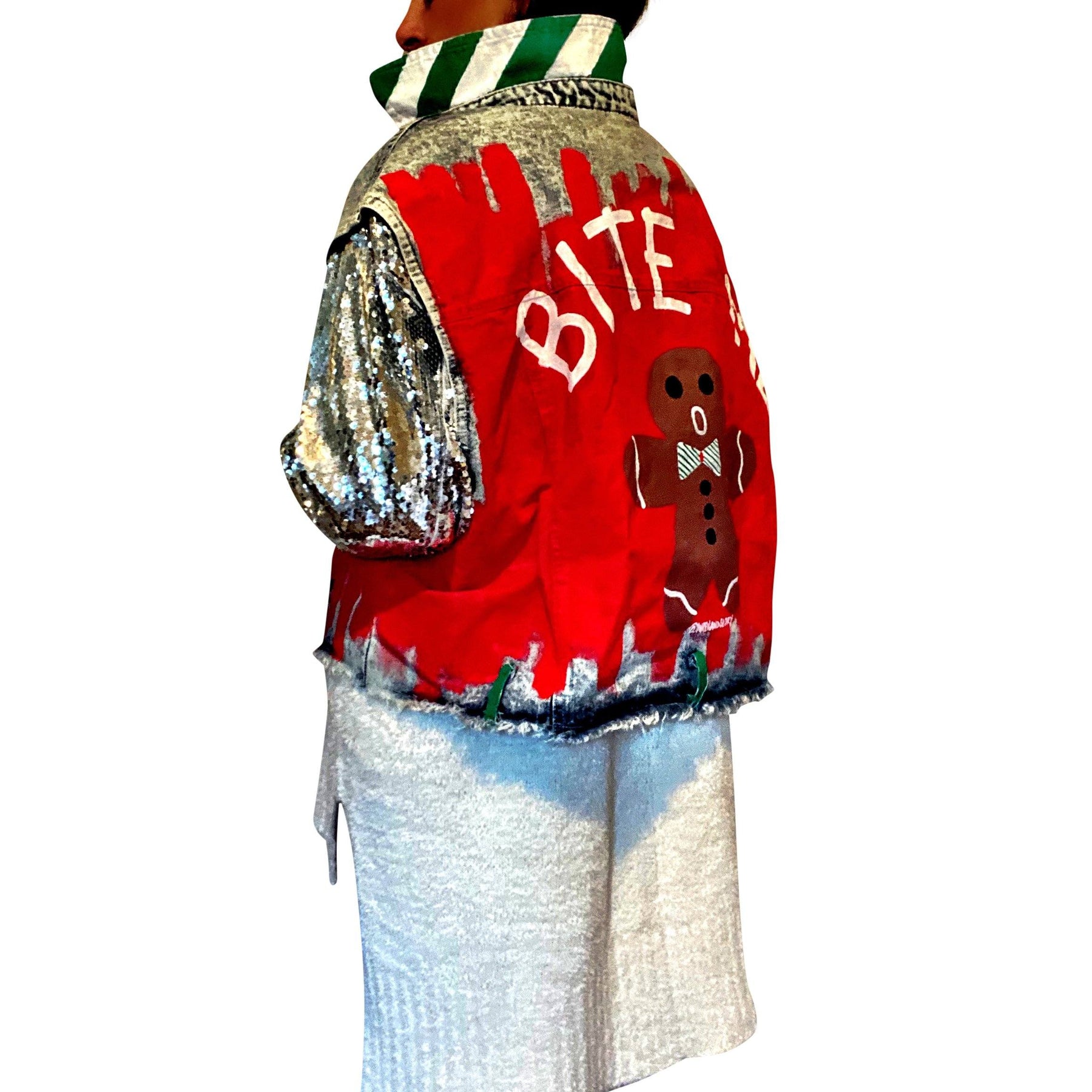 Blue denim jacket with sequined sleeves. Red base painted throughout, with gingerbread man on back, and BITE ME in semi circle above it. Signed @wrenandglory.