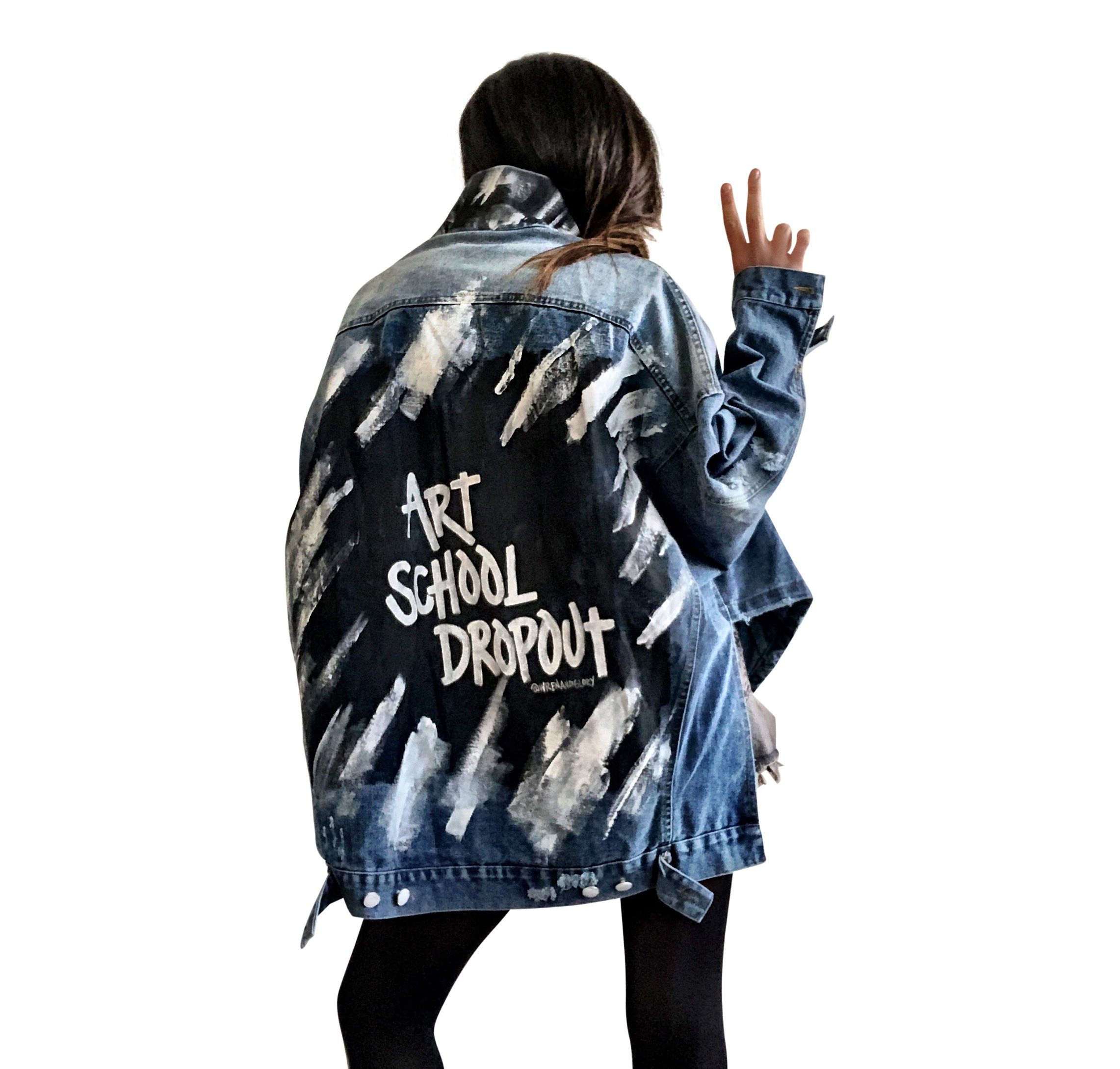 Dark blue denim jacket with long back. White and black pattern painted on back, with ART SCHOOL DROPOUT painted over it in white. Collar and front pockets painted with black and white pattern. Signed @wrenandglory.