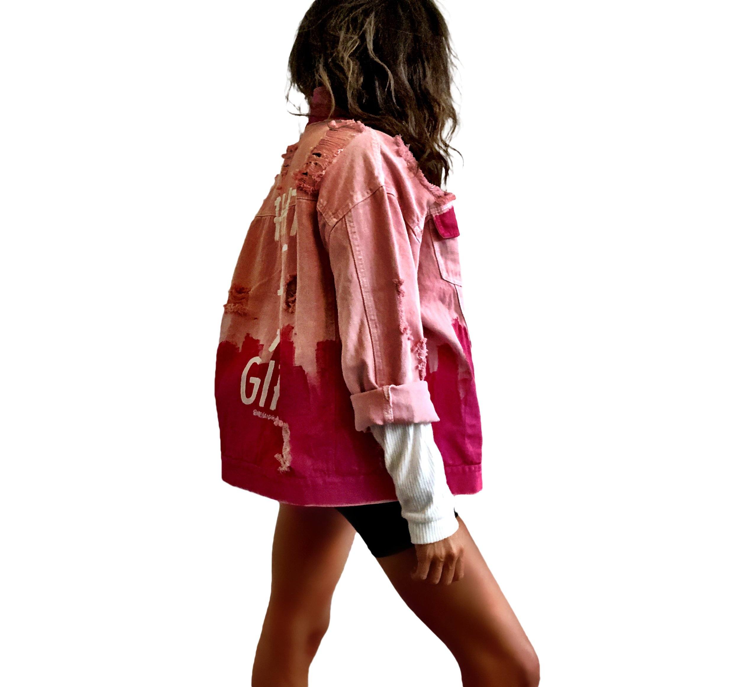 Pink /blush colored denim. Hot pink painted along the bottom half of the jacket, with FIGHT LIKE A GIRL painted in white on back. Small Breast Cancer Awareness ribbon painted on front upper pocket. Signed @wrenandglory.