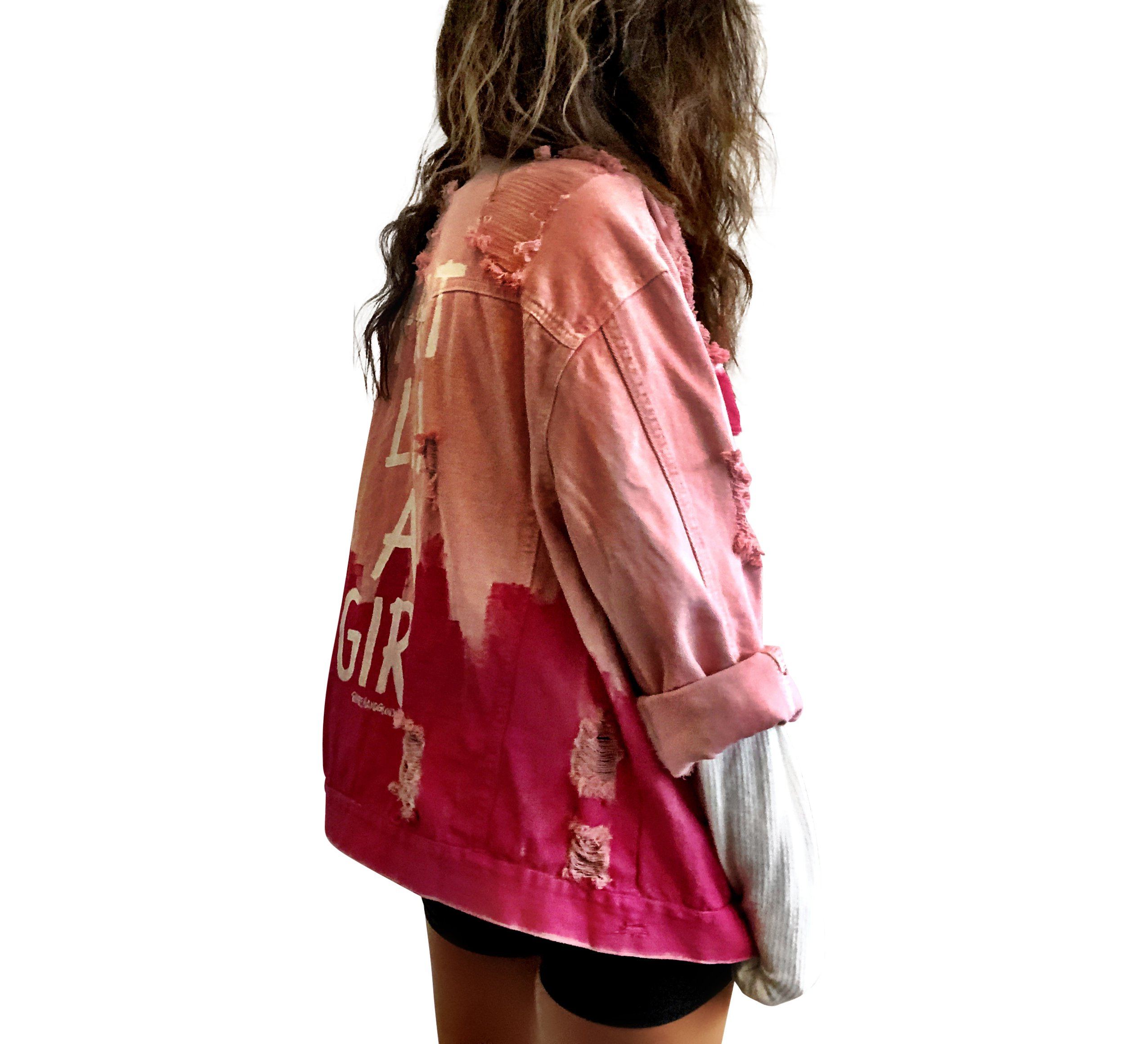 Pink /blush colored denim. Hot pink painted along the bottom half of the jacket, with FIGHT LIKE A GIRL painted in white on back. Small Breast Cancer Awareness ribbon painted on front upper pocket. Signed @wrenandglory.