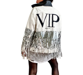 White denim jacket with black sequin fringes hanging off on bottom half of jacket, and below elbows, VIP painted in large on back. Pockets and collar painted black. Signed @wrenandglory.