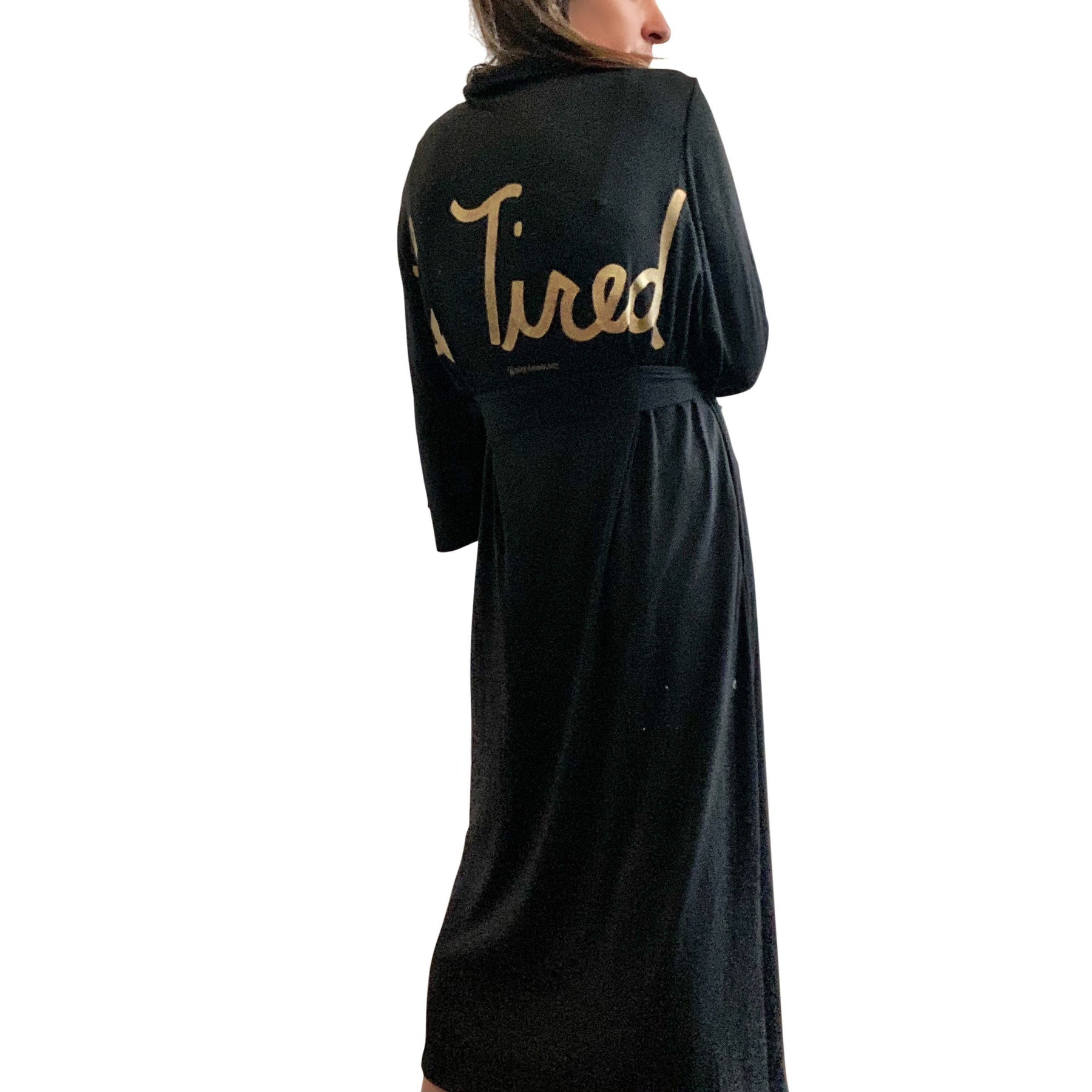 Black, super soft, stretch cotton. robe. LE TIRED painted on the back in gold. Belted, with inside ties for secure closure. Signed @wrenandglory.