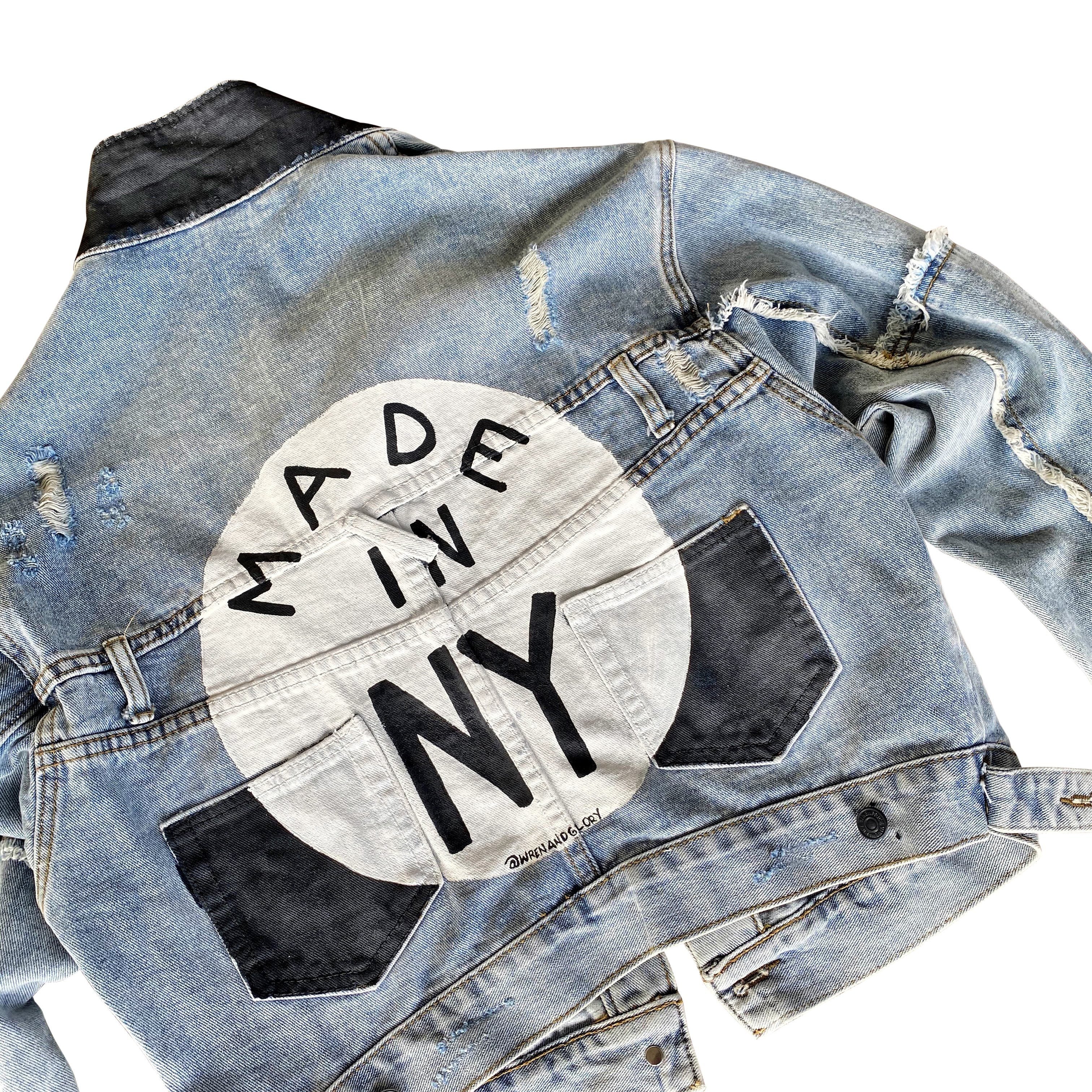 Lighter blue denim wash. White circle, painted MADE IN NYC inside in black. Pockets and hems painted black Signed @wrenandglory.