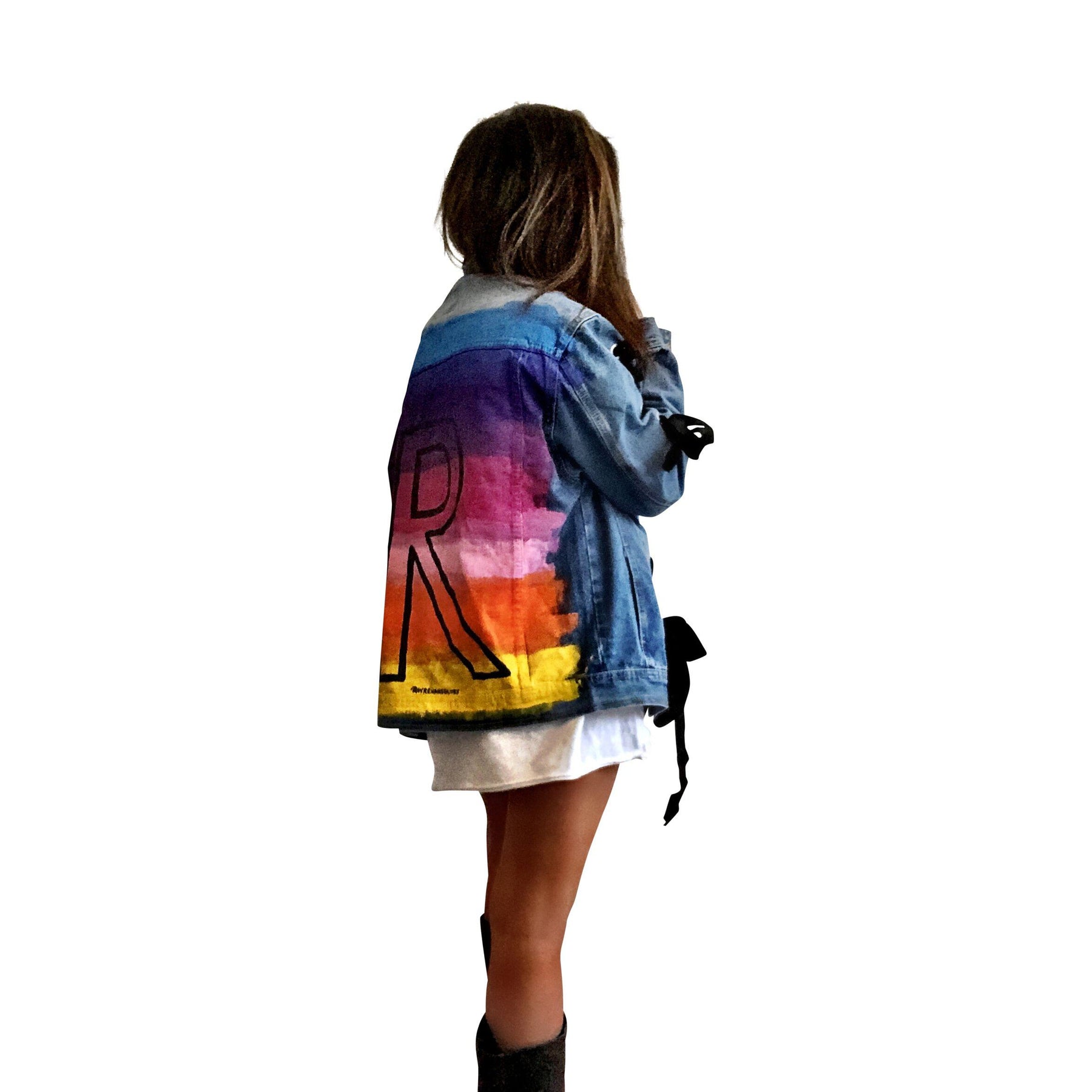 Dark blue denim wash, with velvert ribbon threaded through arms and front, lower left side. Ombre of colored striped on back, with large black initial painted in open block font over the colors. 'BE THE MAGIC' painted on color in black. Please specify initial above. Signed @wrenandglory.