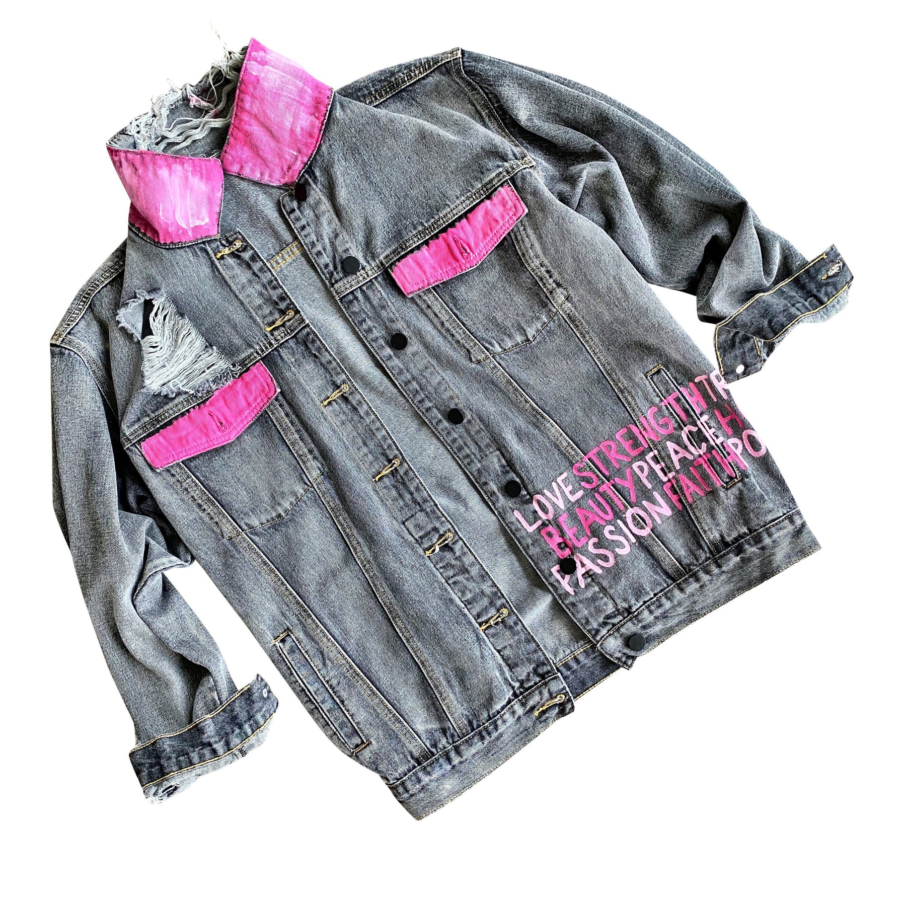 Faded black denim. Pink ombre Breast Cancer ribbon painted in large on back. Love, Strength, Trust, Beauty, Peace, Hope, Passion, Faith, Power painted in light & bright pink on the front. Collar painted in pink ombre. Signed @wrenandglory.