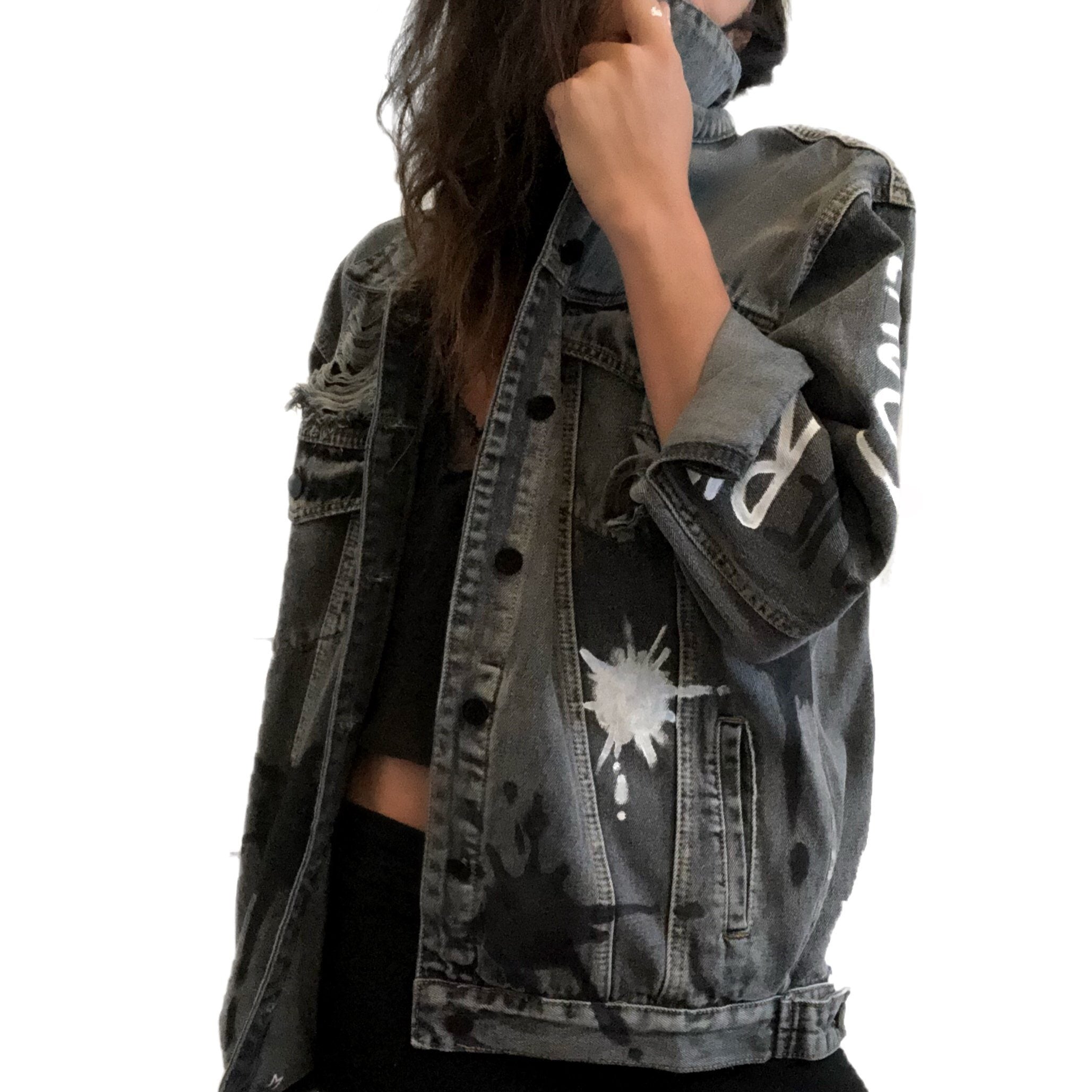 Faded black denim wash. Large white initial on back, with painted white and black 'splatters' 'Enjoy The Ride' painted in black and white down the arm. Signed @wrenandglory.