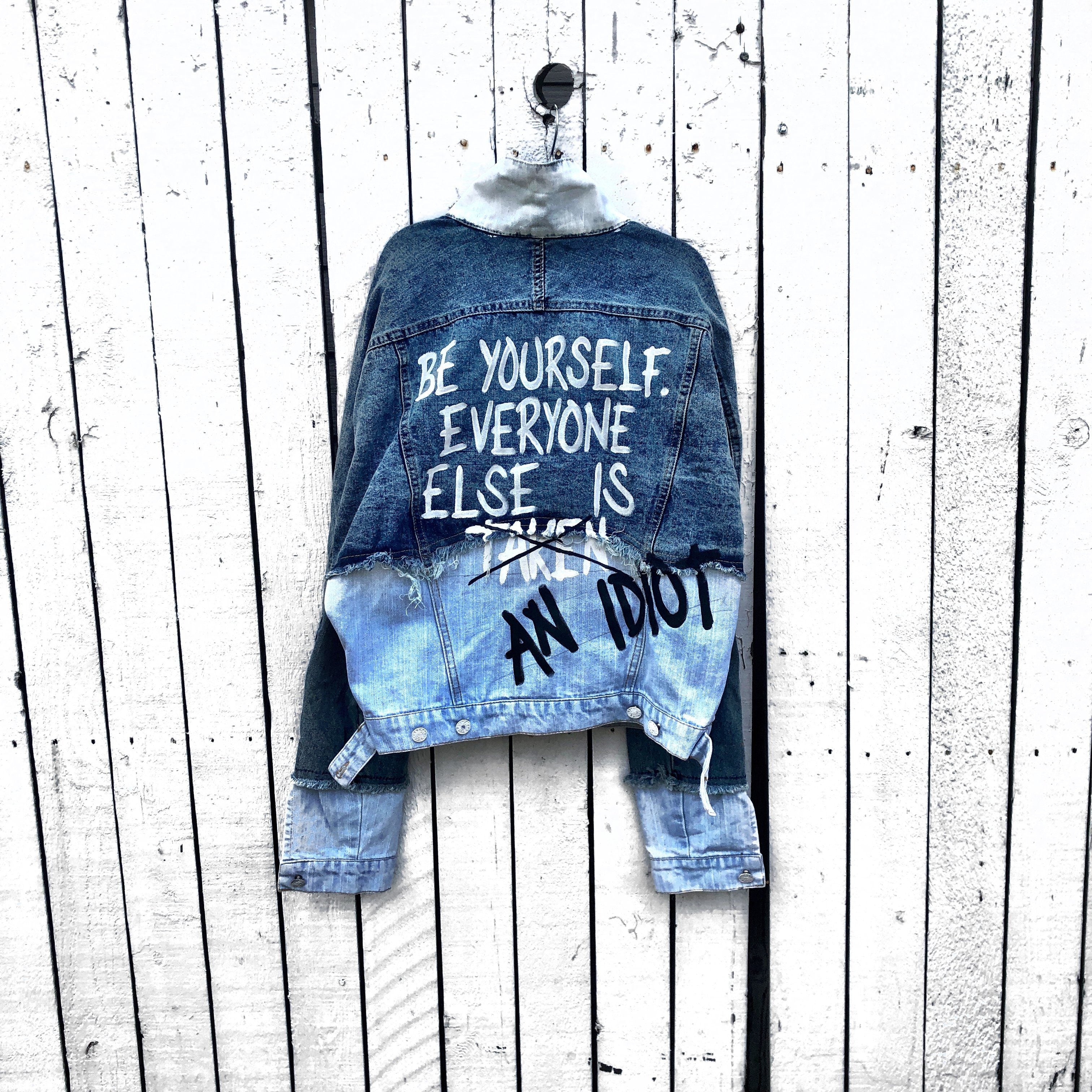 2 tone blue denim wash. BE YOURSELF. EVERYONE ELSE IS TAKEN (CROSSED OUT) AN IDIOT painted in white & black on back. Signed @wrenandglory.
