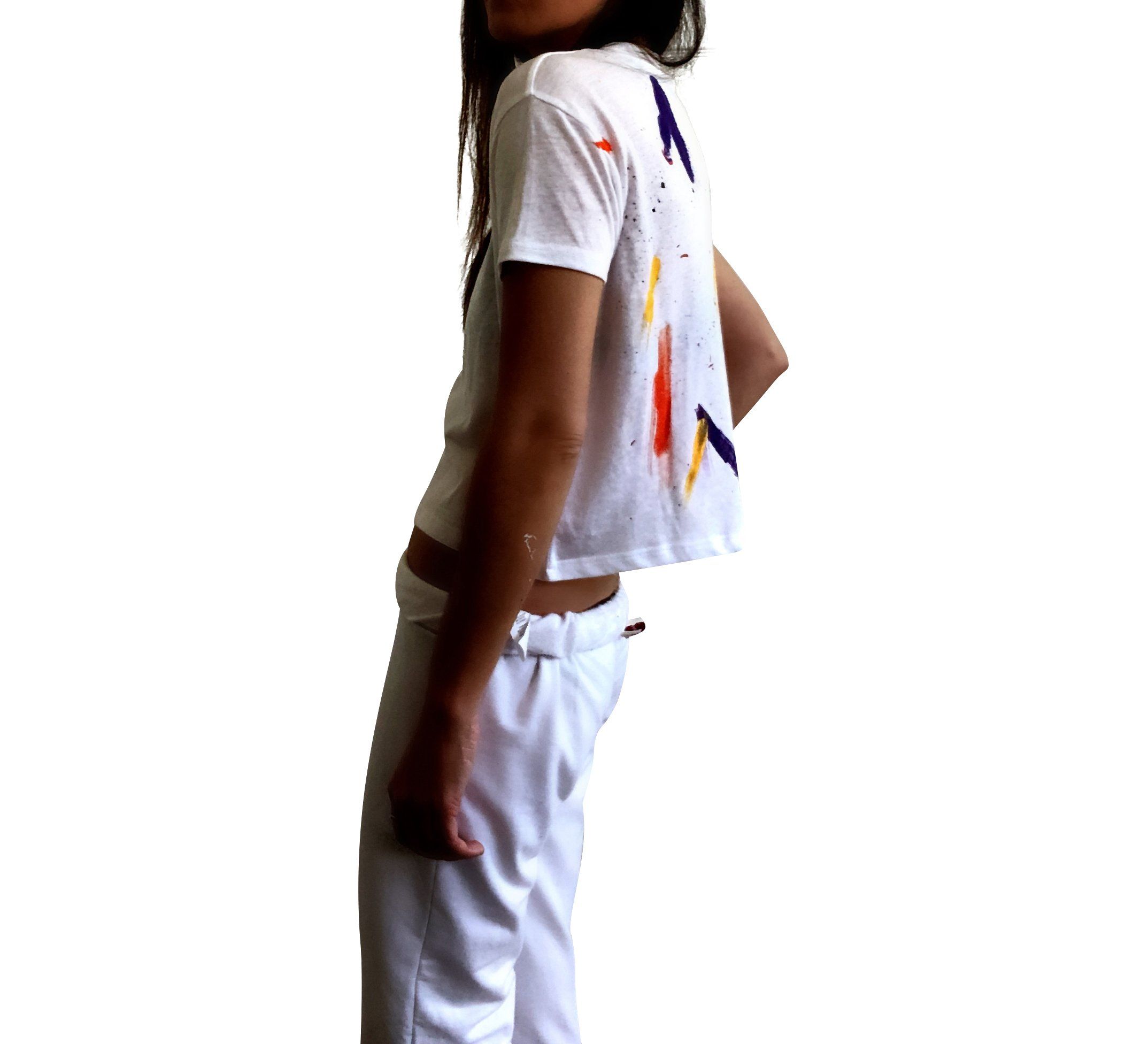 The perfect cropped white T shirt. Assorted color splatter and stripes painted on back, with small heart painted on front, upper left side in red. Signed @wrenandglory.