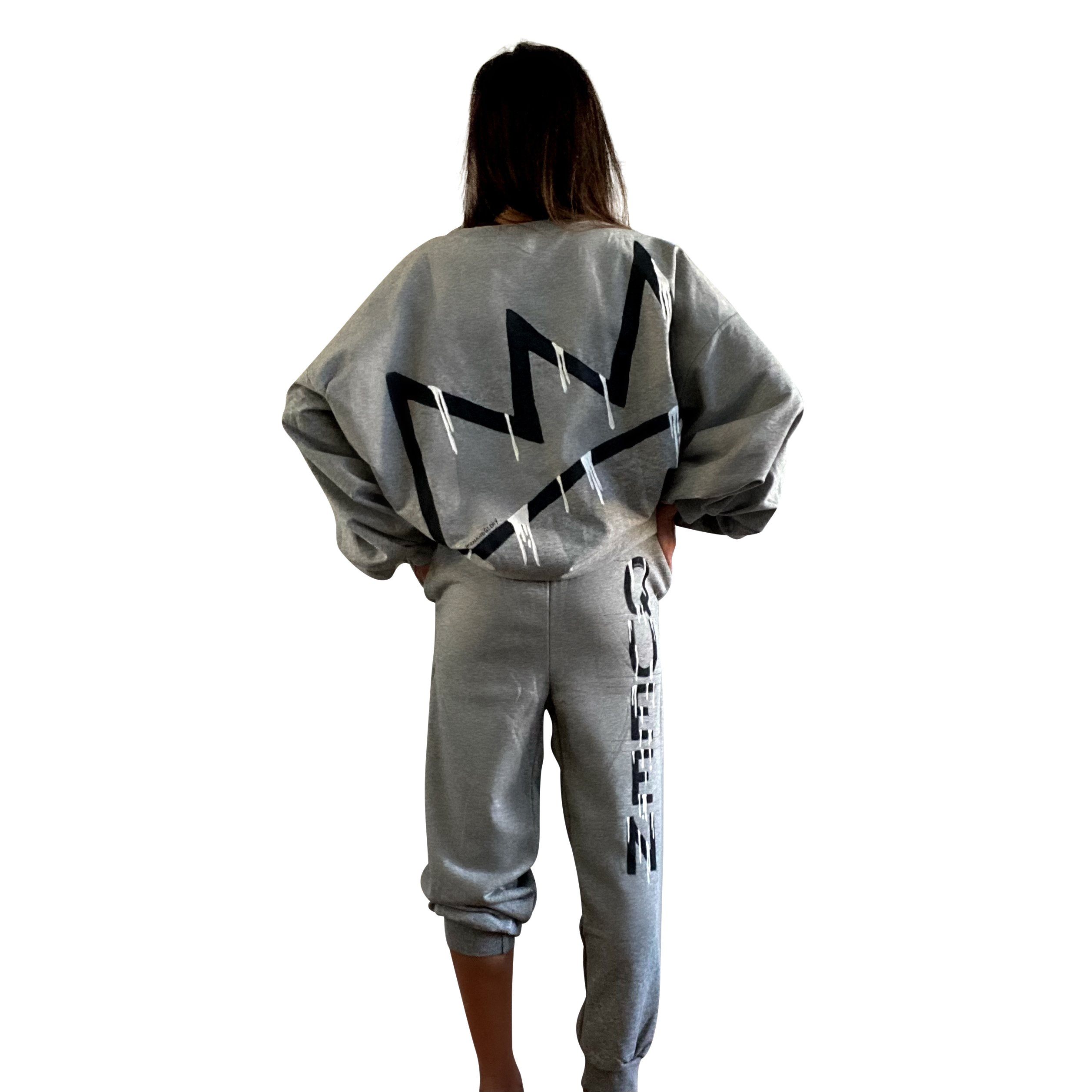 The perfect oversized sweatshirt & jogger loungewear set. TOP: Large crown painted on back in black, with white paint drips. QUEEN painted in black, on front left chest. BOTTOM: QUEEN painted on back going down leg in black, with white paint drips. Assorted sized crowns painted in black and white on front. Signed @wrenandglory on both top and bottom.
