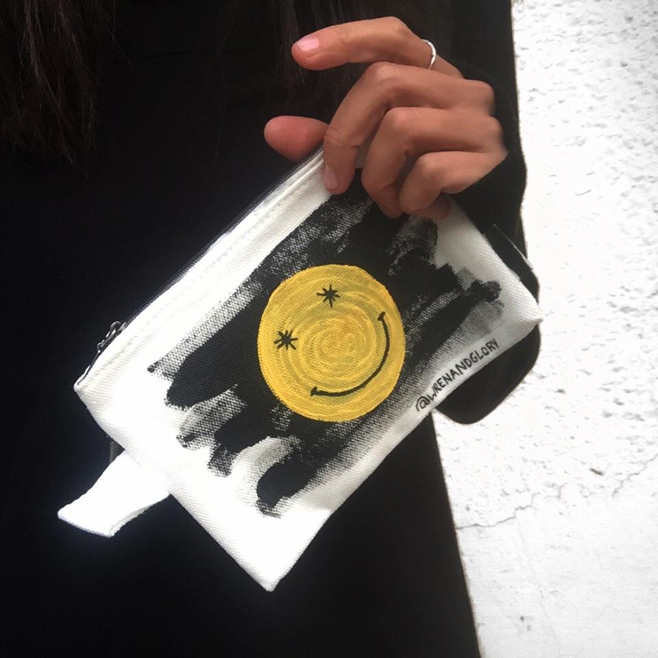 White canvas zippered pouch. Hand painted 'HAPPY DAZE' theme.