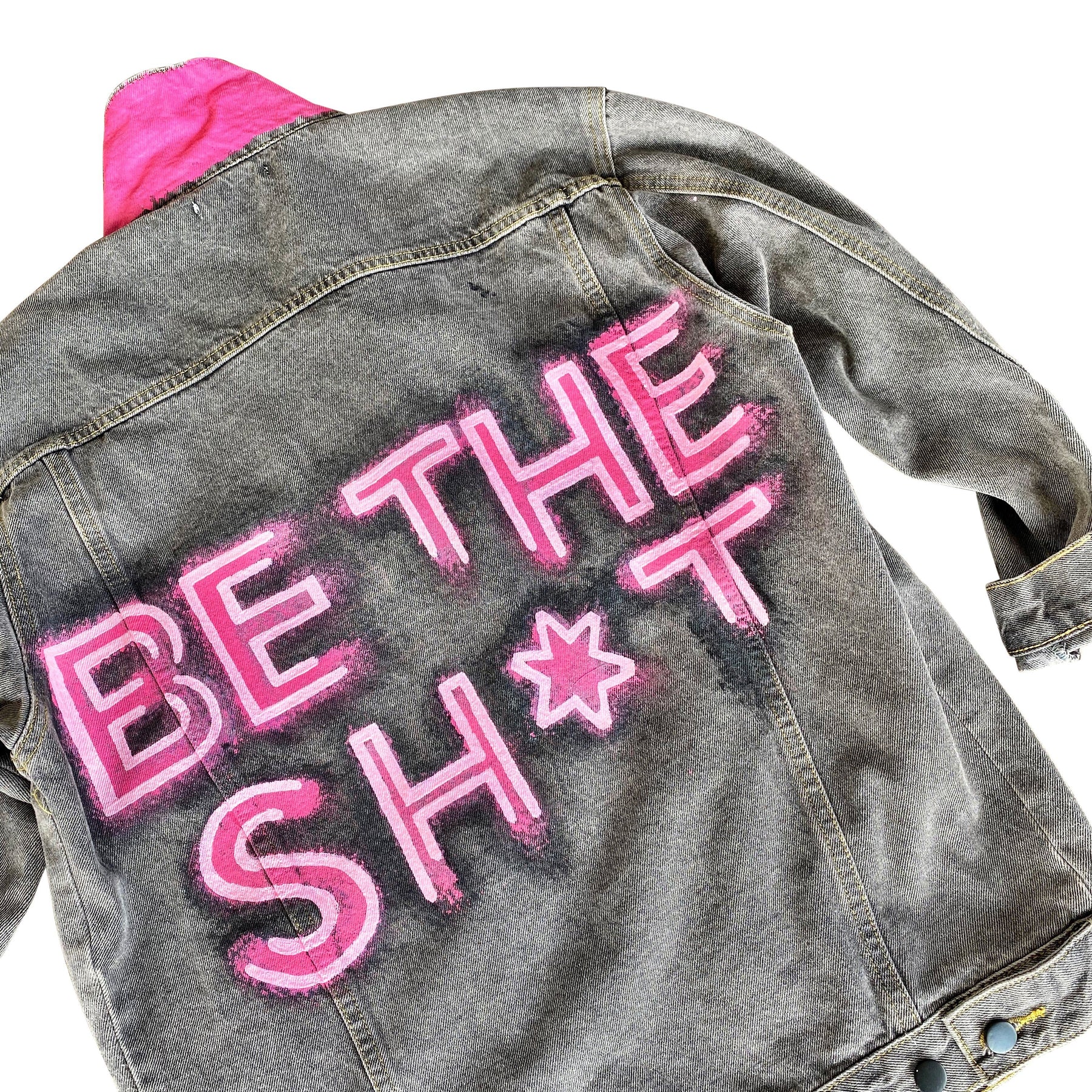 Faded black denim. BE THE SH*T logo painted on back in neon effect in bright pink. Collar and front pockets painted white. Signed @wrenandglory.