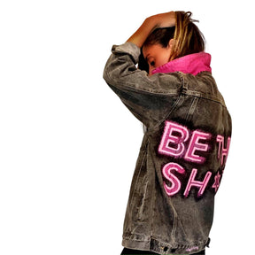 Faded black denim. BE THE SH*T logo painted on back in neon effect in bright pink. Collar and front pockets painted white. Signed @wrenandglory.