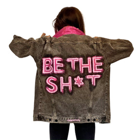 Faded black denim. BE THE SH*T logo painted on back in neon effect in bright pink. Collar and front pockets painted white. Signed @wrenandglory.