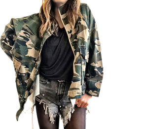 Camo print oversized denim jacket with off white layer inside. DON'T BELIEVE EVERYTHING YOU THINK painted on the back in white, drip effect font. Signed @wrenandglory.
