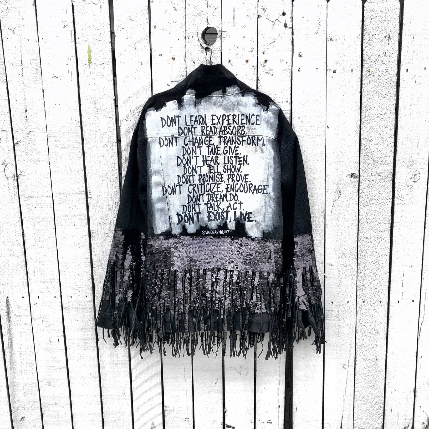 Black denim jacket with black sequin fringes hanging off on bottom half of jacket, and below elbows, Positive motivation painted in black, over white base, on back. Inspired by resolutions for 2020. Signed @wrenandglory.