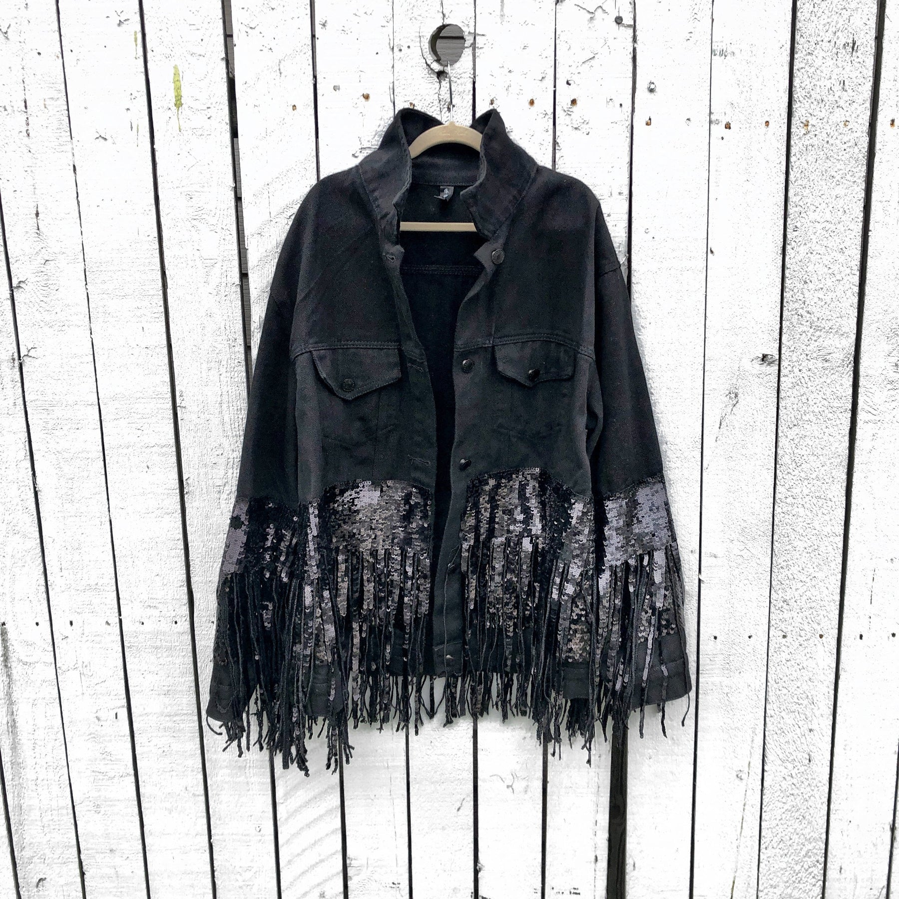 Black denim jacket with black sequin fringes hanging off on bottom half of jacket, and below elbows, Positive motivation painted in black, over white base, on back. Inspired by resolutions for 2020. Signed @wrenandglory.