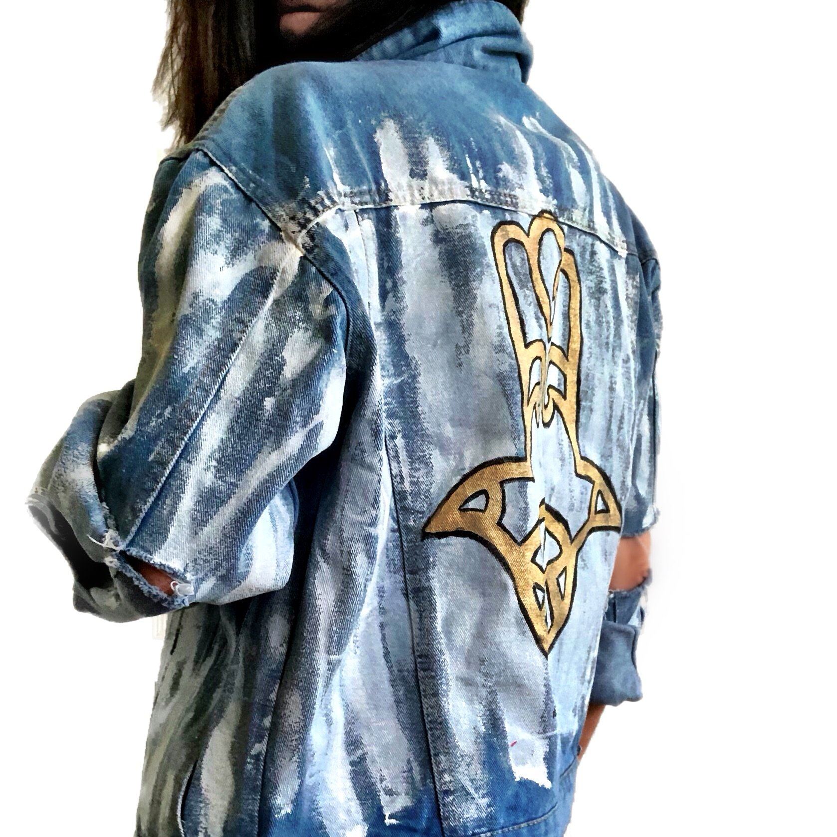 Medium blue denim wash. 'White base all over, with black and gold Hamsa painted on the back. Signed @wrenandglory.