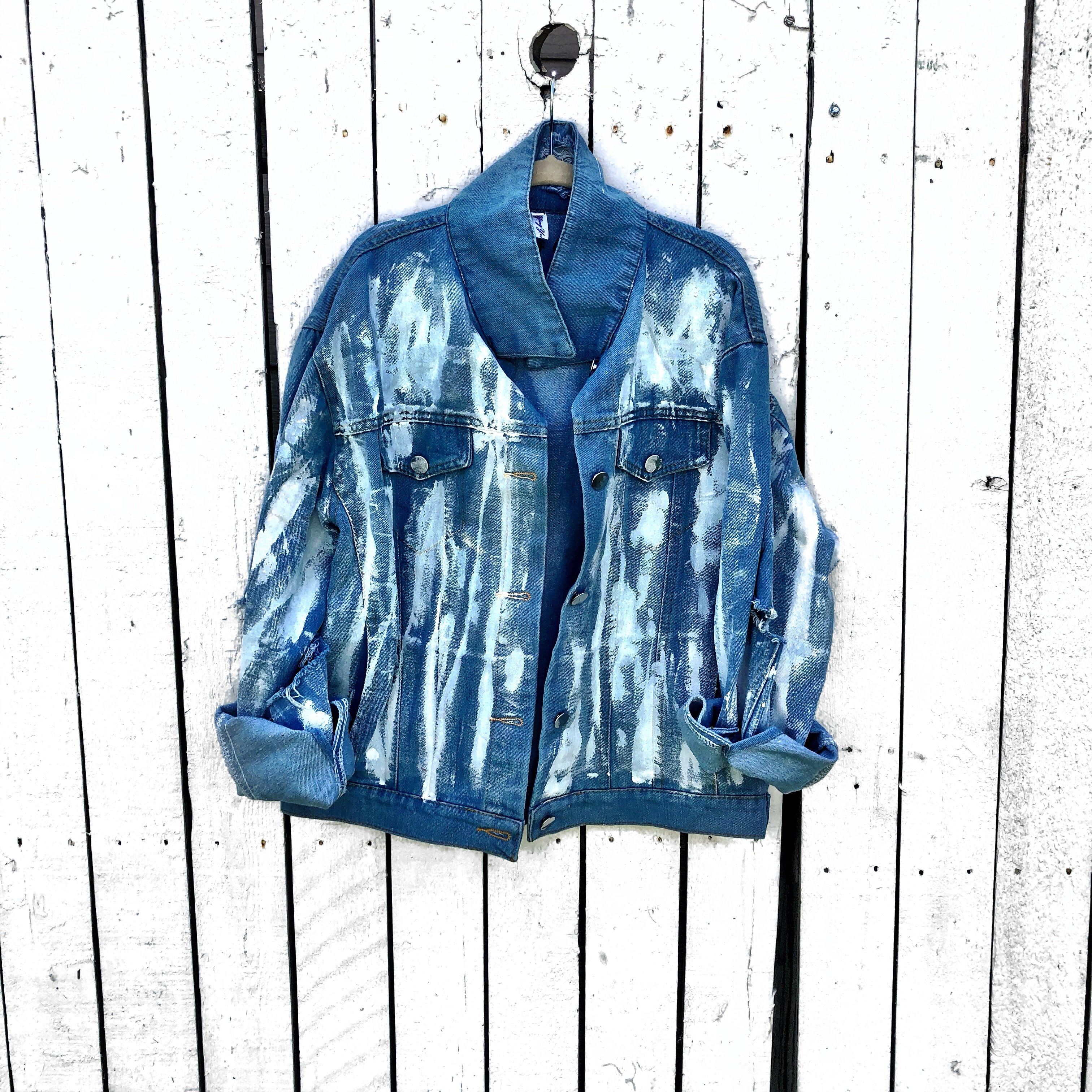 Medium blue denim wash. 'White base all over, with black and gold Hamsa painted on the back. Signed @wrenandglory.