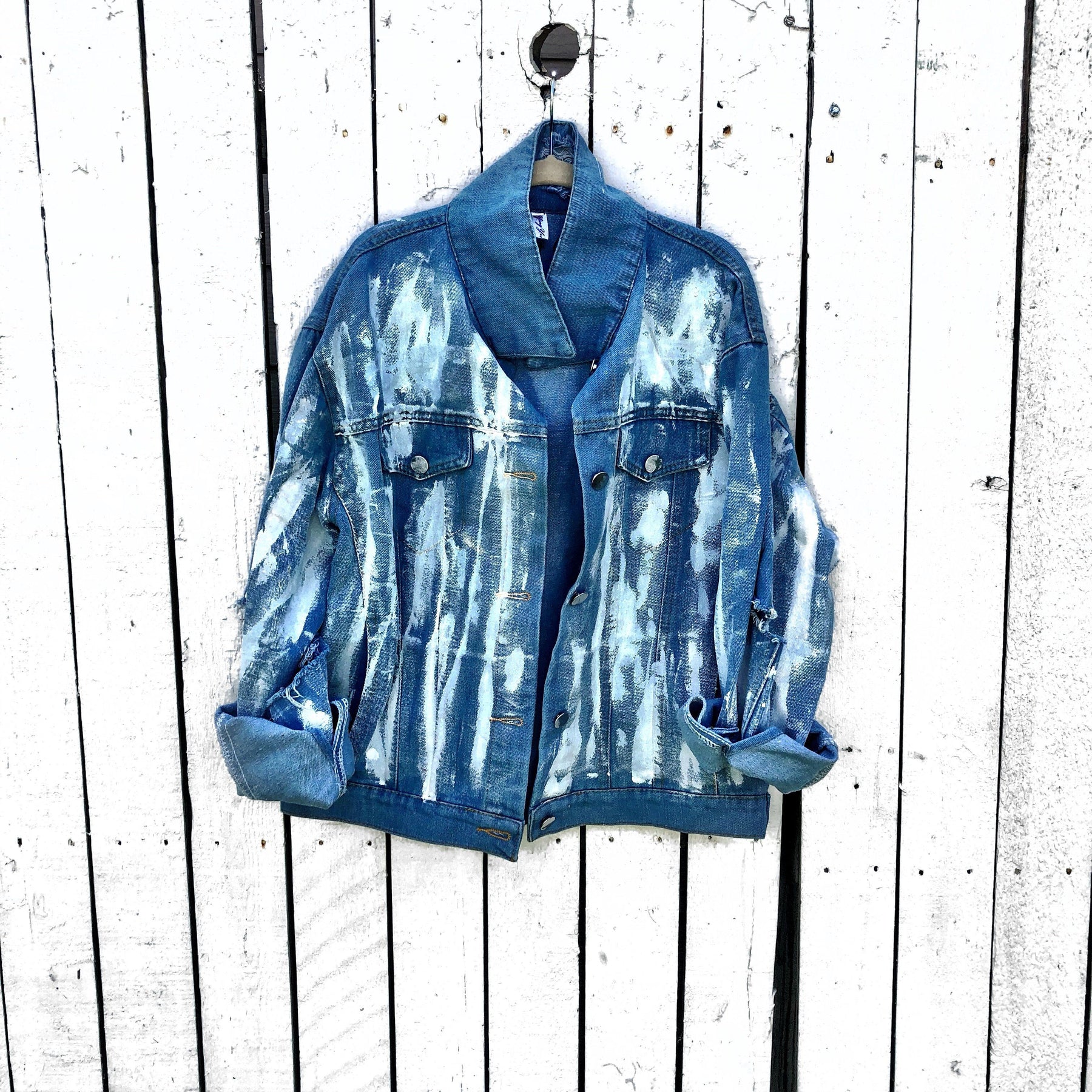 Medium blue denim wash. 'White base all over, with black and gold Hamsa painted on the back. Signed @wrenandglory.