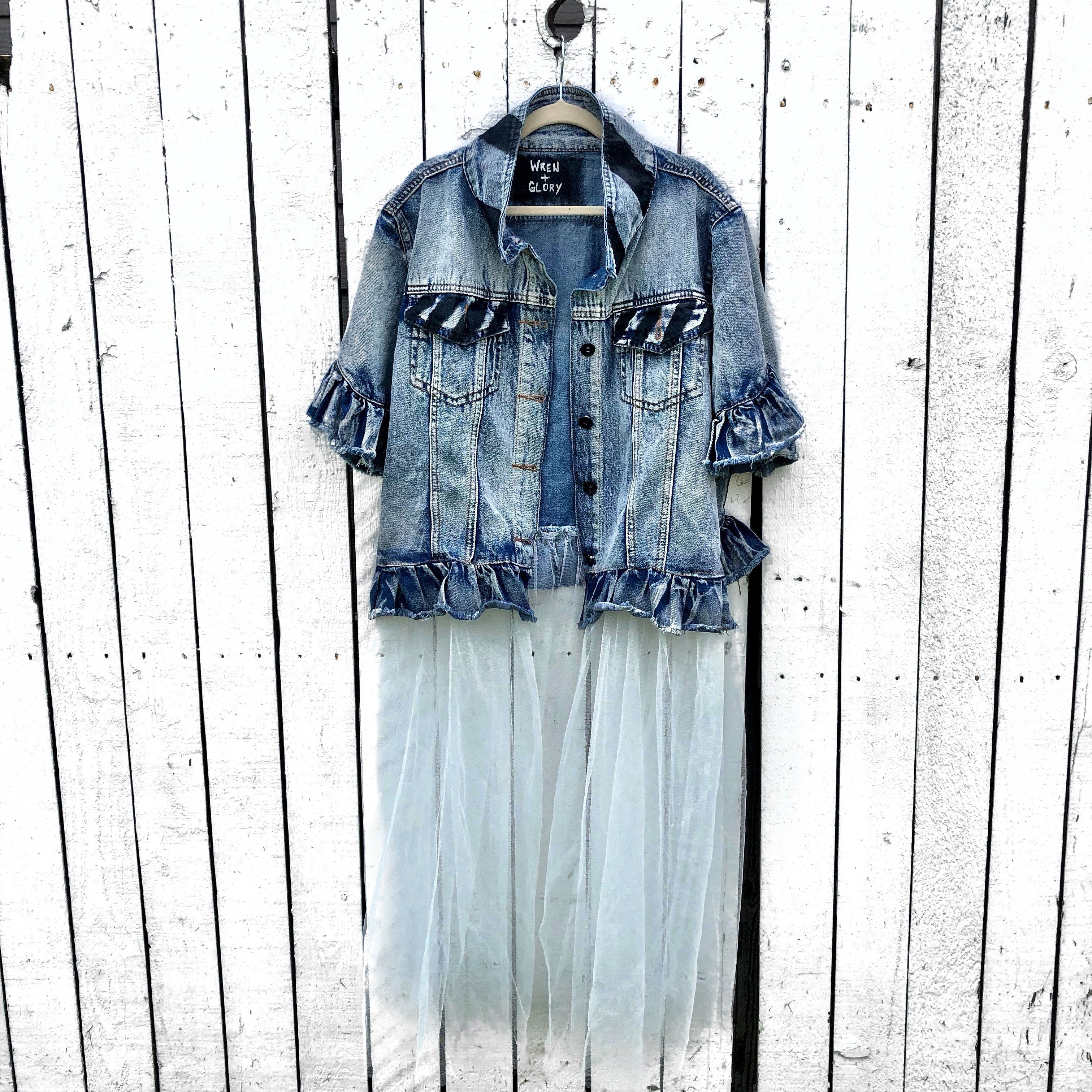 Medium blue denim short sleeve jacket with layer of long white tulle. 'But Is It Art?' painted in black on the back, with black stripes on front pockets and collar. Signed @wrenandglory.