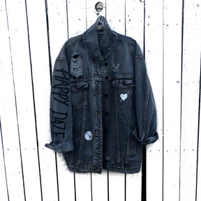 Yellow smiley on faded black denim jacket, with hand painted symbols throughout. Hand painted with white, yellow and black. 'HAPPY DAZE' written down left arm. Signed @wrenandglory