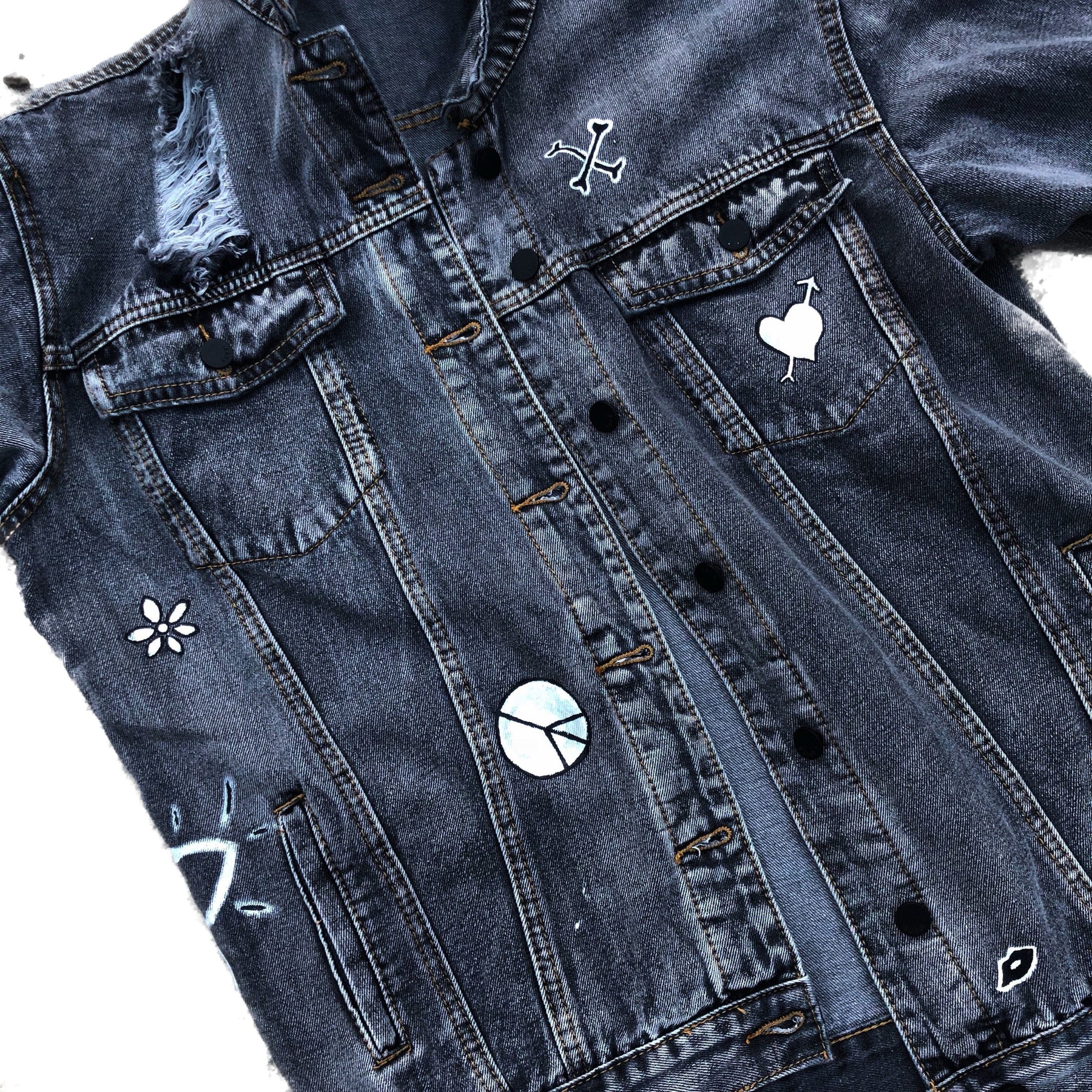 Yellow smiley on faded black denim jacket, with hand painted symbols throughout. Hand painted with white, yellow and black. 'HAPPY DAZE' written down left arm. Signed @wrenandglory
