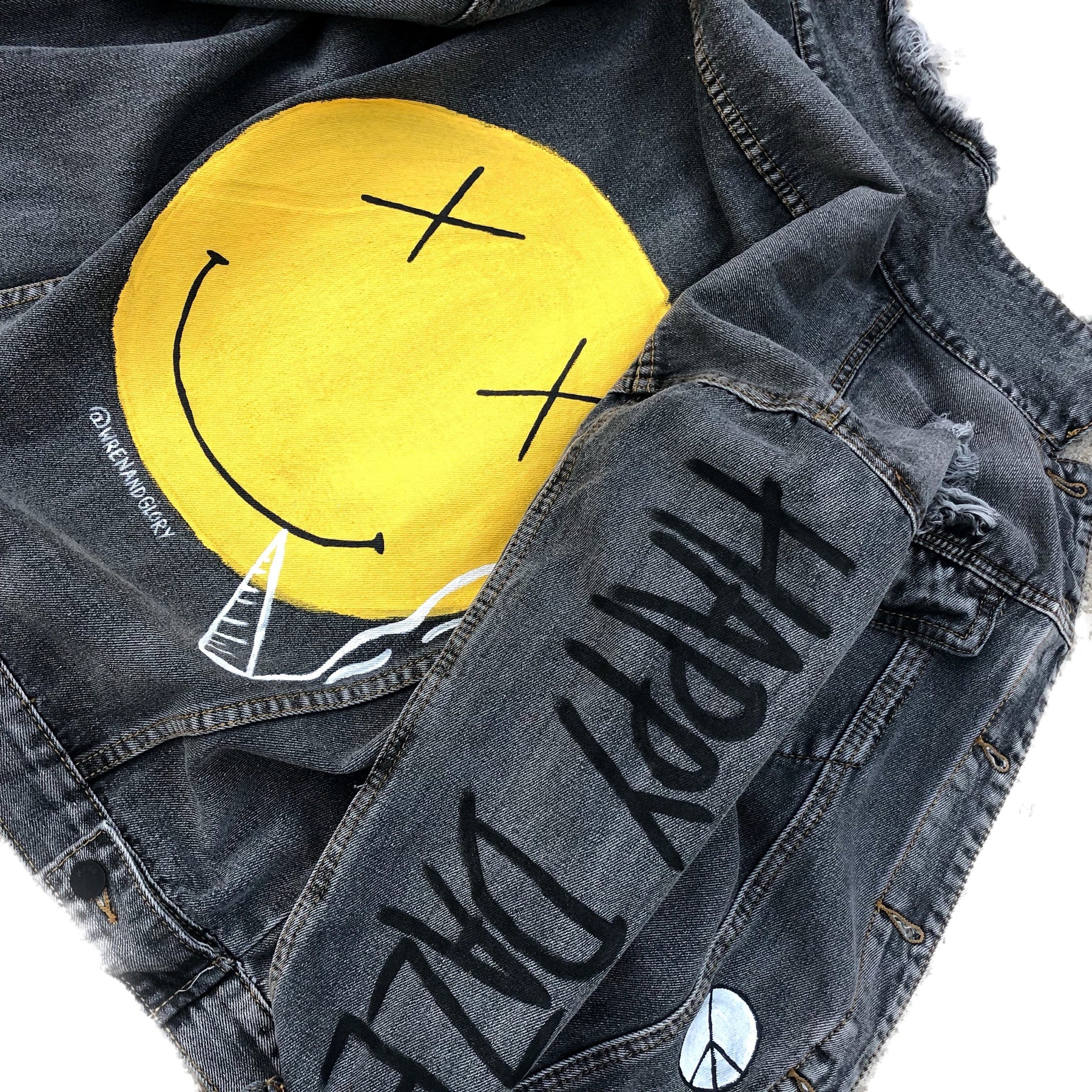 Yellow smiley on faded black denim jacket, with hand painted symbols throughout. Hand painted with white, yellow and black. 'HAPPY DAZE' written down left arm. Signed @wrenandglory