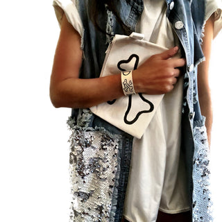 White denim zippered pouch Hand painted 'Bad Bitch' on one side, crossbones on the other.