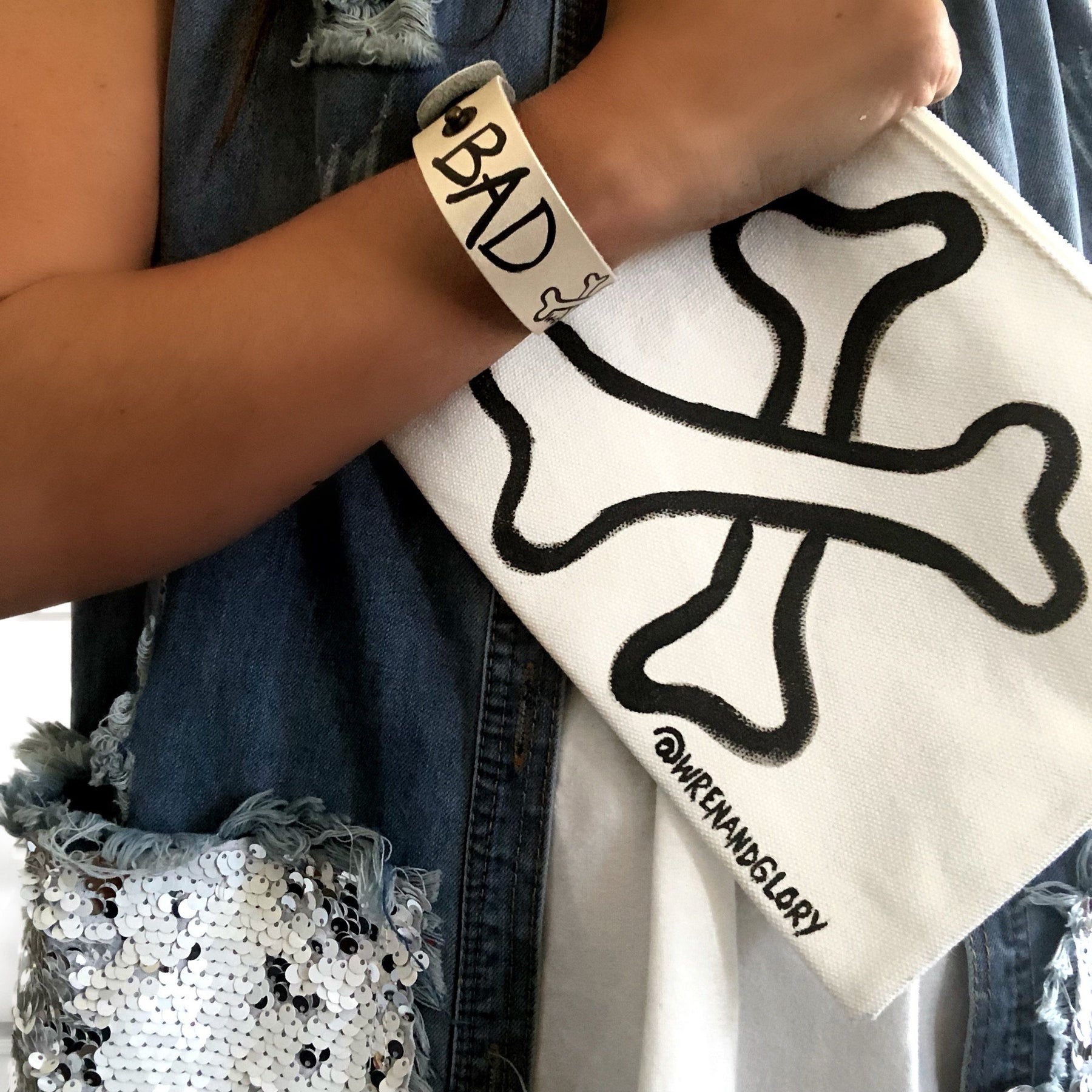 Hand made leather bracelet, hand painted with Bad B*tch and crossbones.  White leather, black paint. Signed W+G