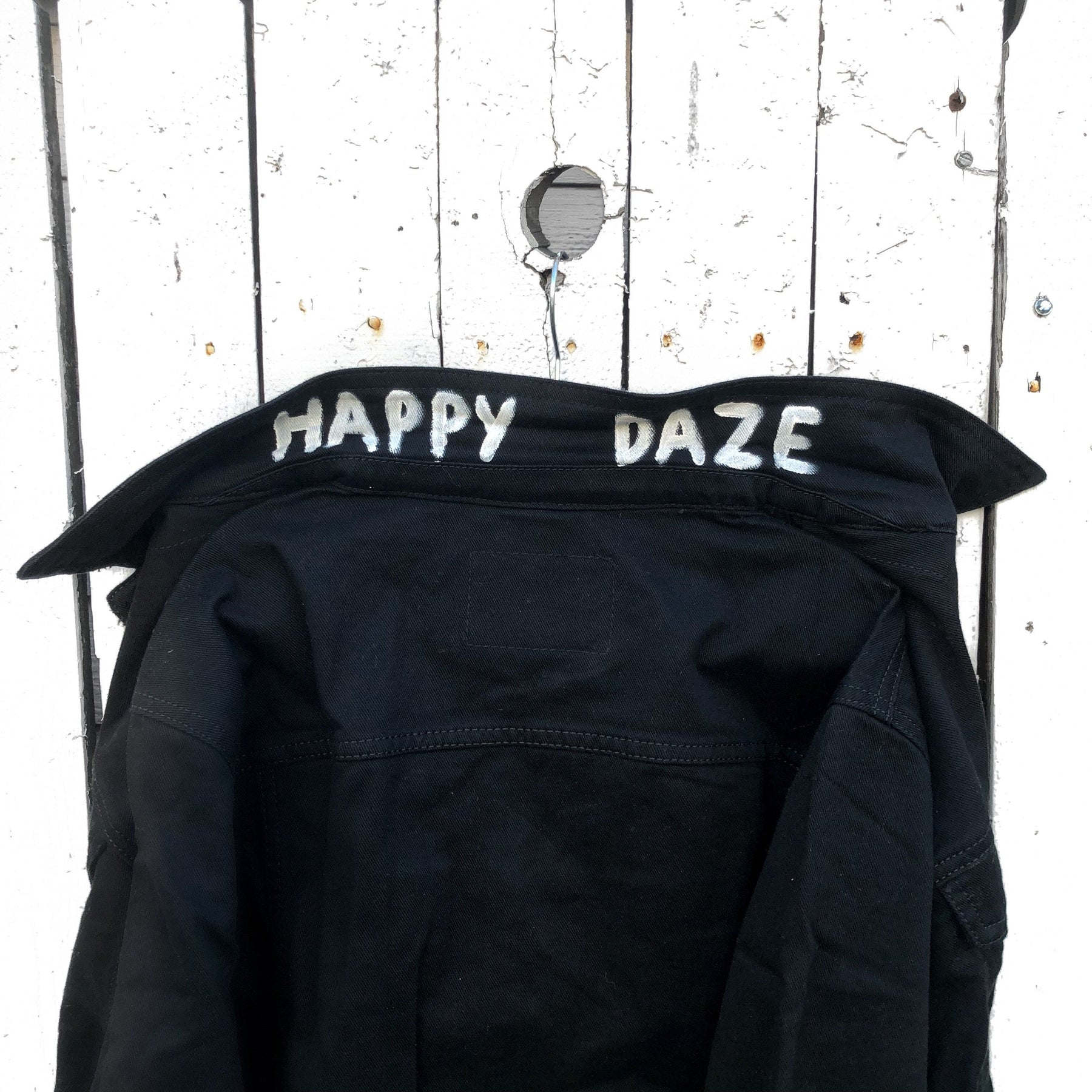 Black denim. Yellow smiley with smoking utensil on back. Happy Daze painted on collar in white. Signed @wrenandglory.