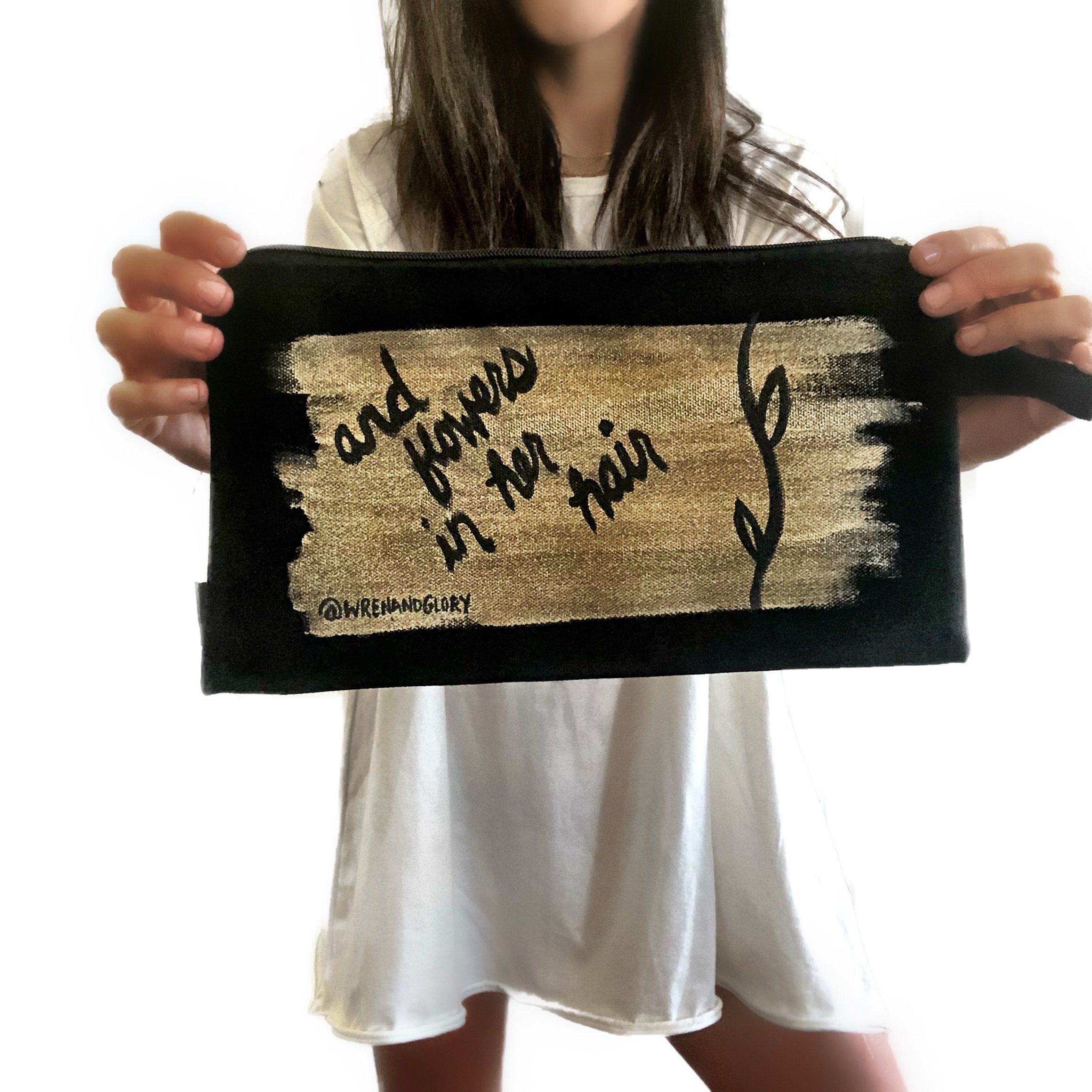Black denim zippered pouch Hand painted 'She Had Love In Her Eyes' on one side, and 'And Flowers In Her Hair' on the other.