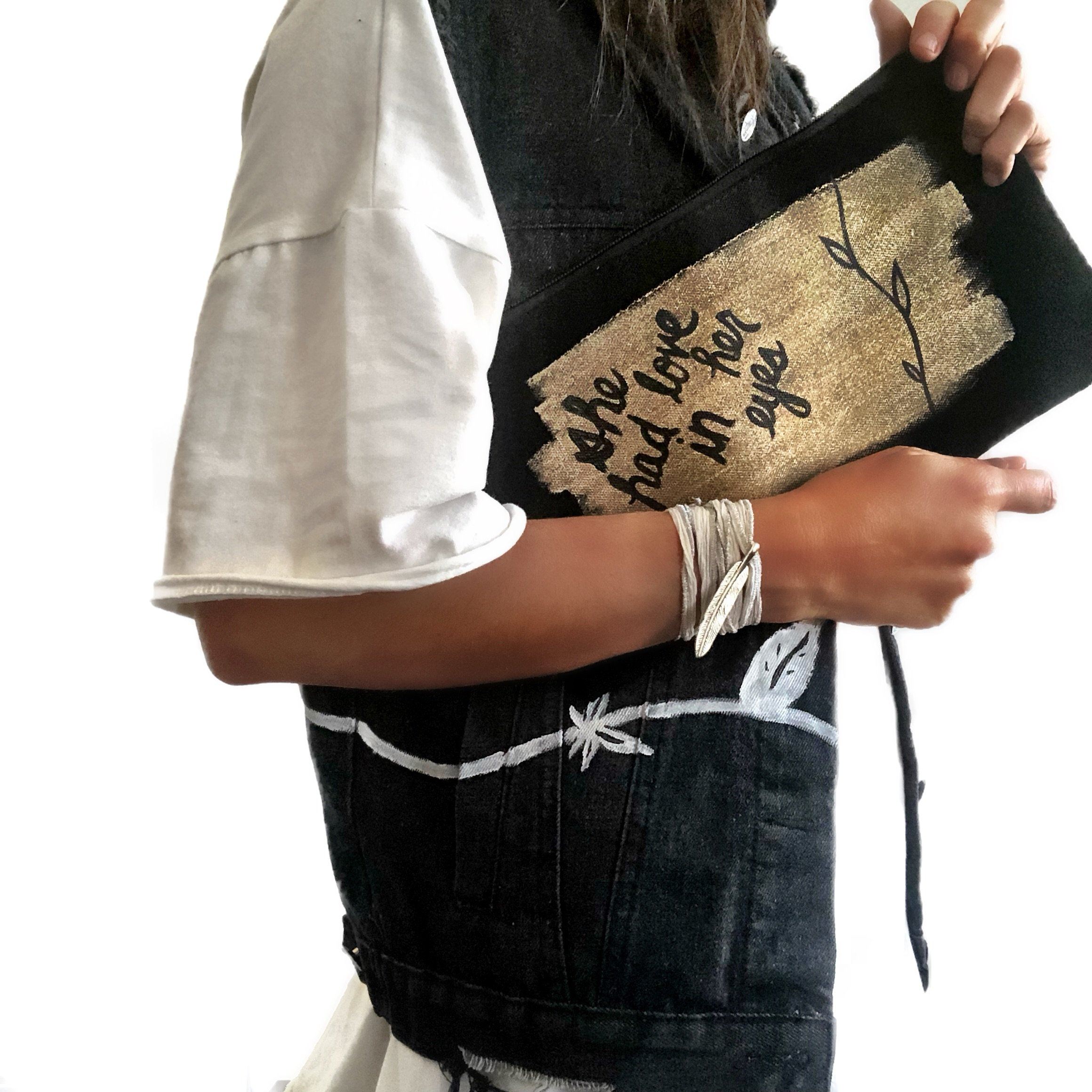 Black denim zippered pouch Hand painted 'She Had Love In Her Eyes' on one side, and 'And Flowers In Her Hair' on the other.