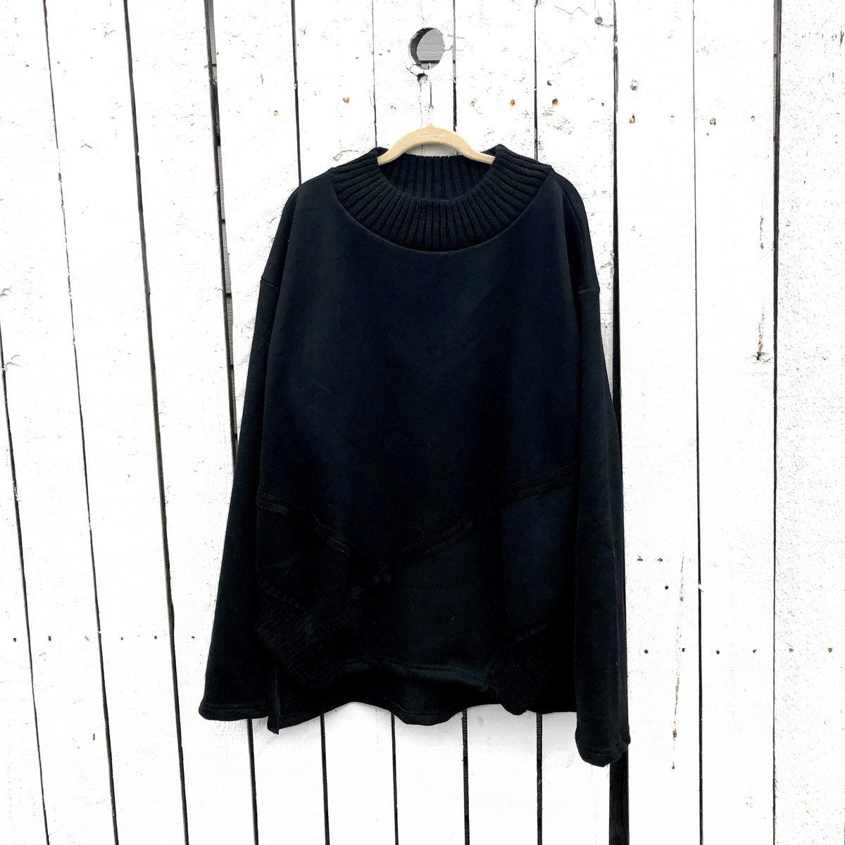 Slight mock neck black sweater. Large silver crown, with white drip effect, on back. Signed @wrenandglory.