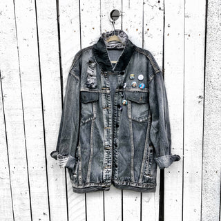 Faded black denim. Boombox painted on back over white base, with wording 'LIVE, LOVE, MUSIC'. Assorted 1 inch pins on front upper side. Signed @wrenandglory.
