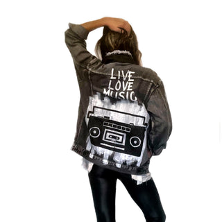 Faded black denim. Boombox painted on back over white base, with wording 'LIVE, LOVE, MUSIC'. Assorted 1 inch pins on front upper side. Signed @wrenandglory.