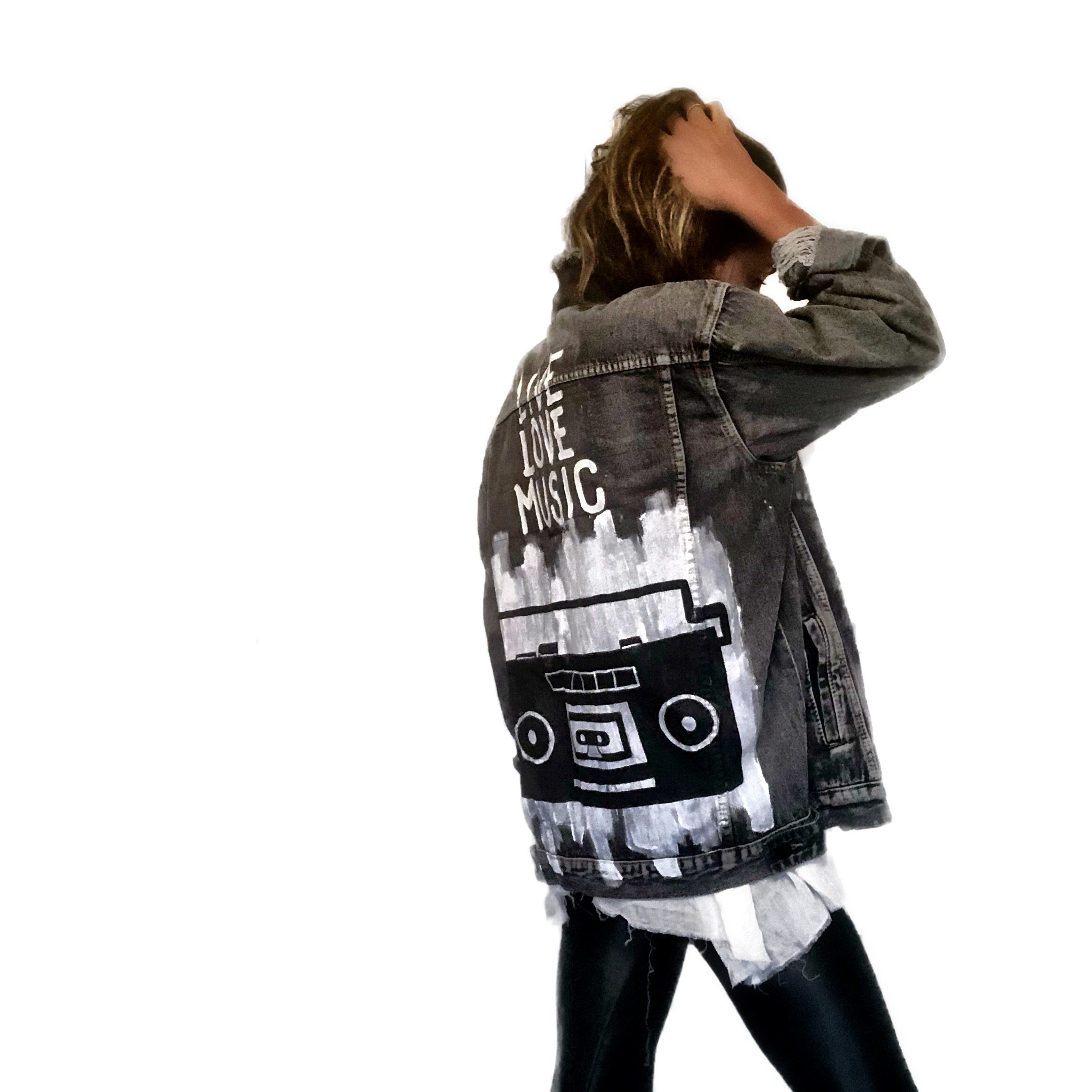 Faded black denim. Boombox painted on back over white base, with wording 'LIVE, LOVE, MUSIC'. Assorted 1 inch pins on front upper side. Signed @wrenandglory.