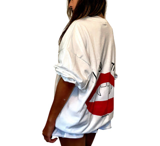 Oversized white sweatshirt. Lips and vampire teeth painted in on back, with with BITE ME painted above. Signed @wrenandglory.