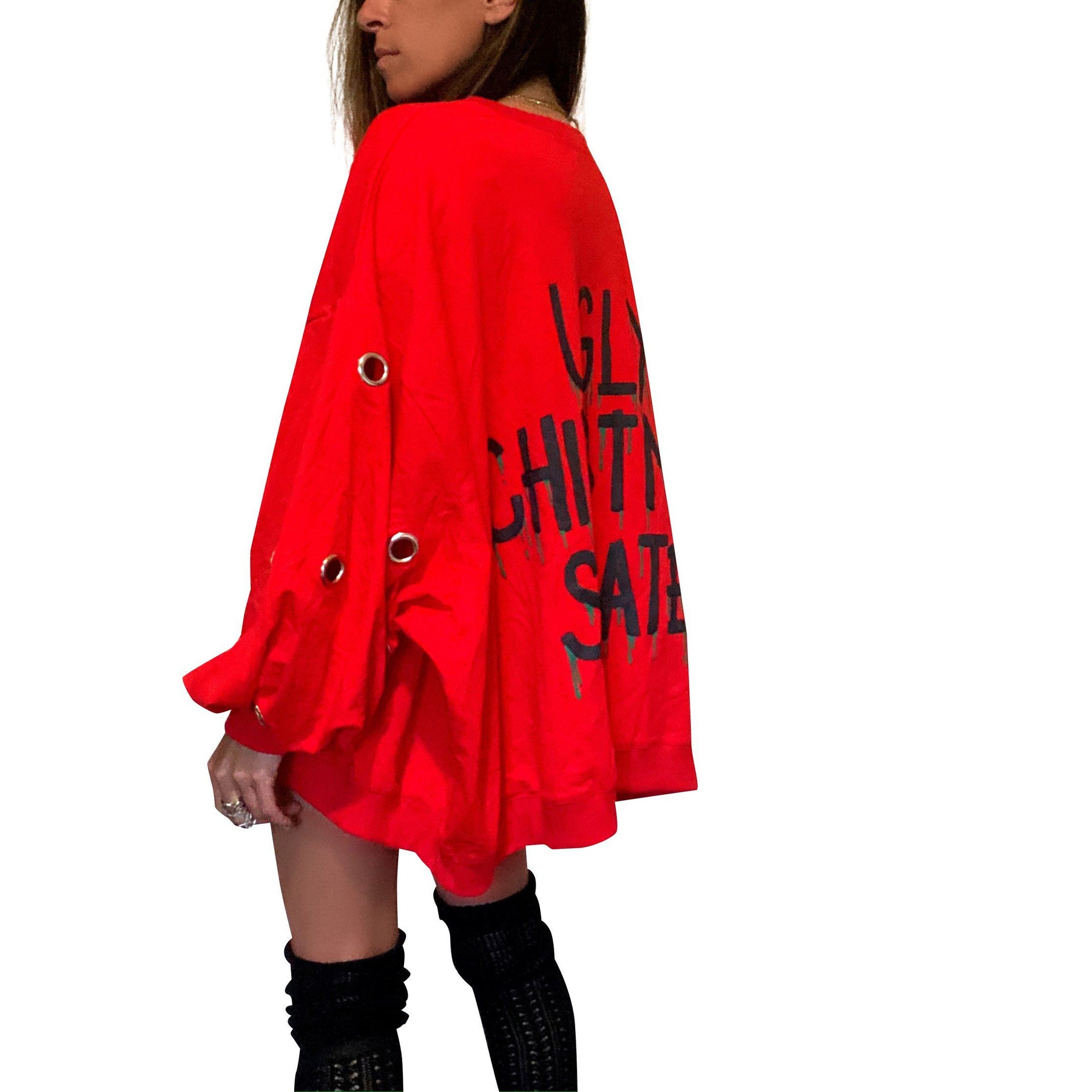 Oversized, batwing red sweatshirt with rings on sleeves. UGLY CHRISTMAS SWEATER painted on the back in black, with green paint drips coming from letters. Signed @wrenandglory