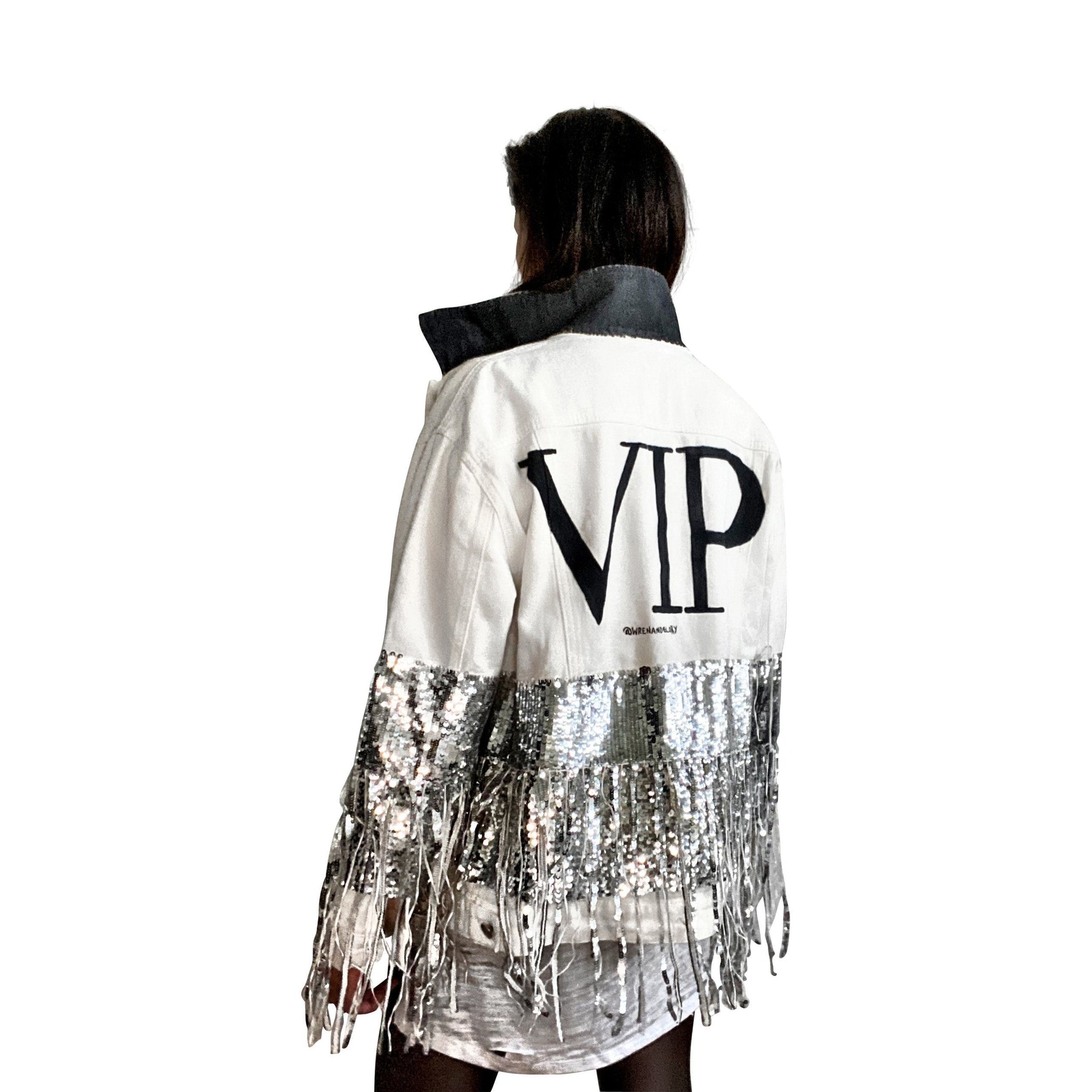 White denim jacket with black sequin fringes hanging off on bottom half of jacket, and below elbows, VIP painted in large on back. Pockets and collar painted black. Signed @wrenandglory.