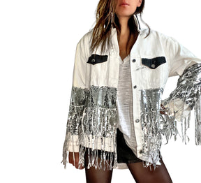 White denim jacket with black sequin fringes hanging off on bottom half of jacket, and below elbows, VIP painted in large on back. Pockets and collar painted black. Signed @wrenandglory.