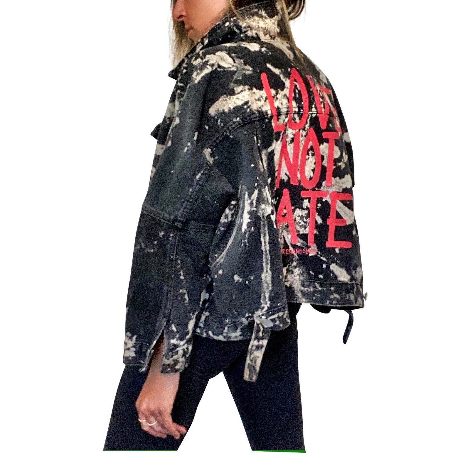 Black denim jacket. Reverse tie dye pattern throughout jacket. LOVE NOT HATE painted in red on back. Signed @wrenandglory