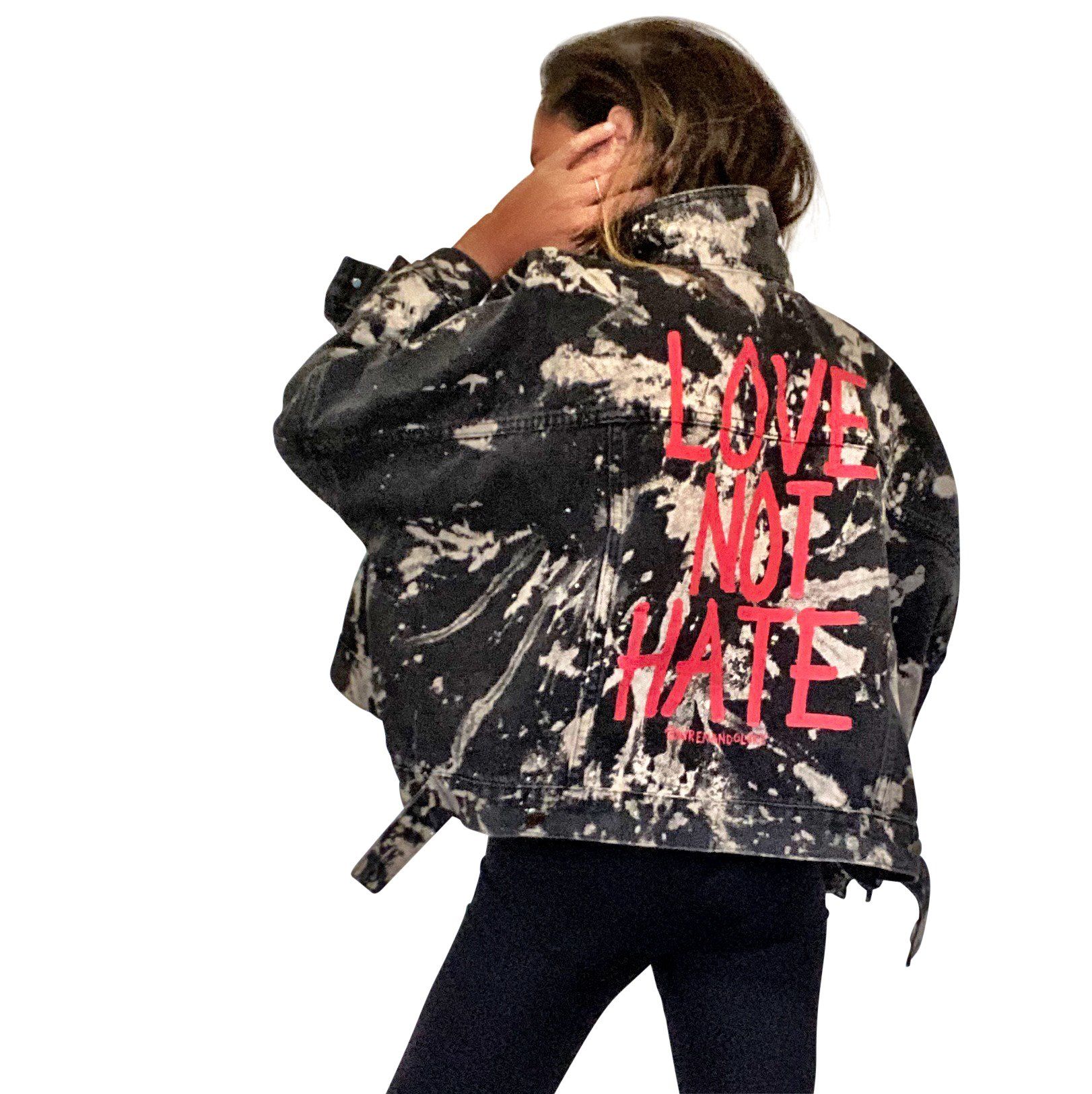 Black denim jacket. Reverse tie dye pattern throughout jacket. LOVE NOT HATE painted in red on back. Signed @wrenandglory