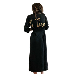 Black, super soft, stretch cotton. robe. LE TIRED painted on the back in gold. Belted, with inside ties for secure closure. Signed @wrenandglory.