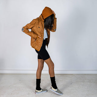 Tan, faux leather jacket with Brown hooded sweatshirt lining the inside and thumbholes at sleeves. 'F*CK DRAMA LET'S PARTY' painted along back of sleeves and upper back of jacket, in black, with white outline. Signed @wrenandglory.