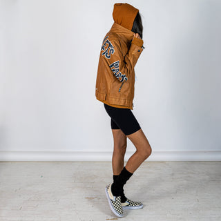 Tan, faux leather jacket with Brown hooded sweatshirt lining the inside and thumbholes at sleeves. 'F*CK DRAMA LET'S PARTY' painted along back of sleeves and upper back of jacket, in black, with white outline. Signed @wrenandglory.
