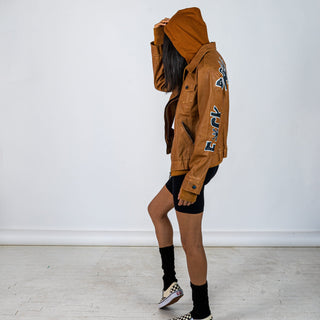 Tan, faux leather jacket with Brown hooded sweatshirt lining the inside and thumbholes at sleeves. 'F*CK DRAMA LET'S PARTY' painted along back of sleeves and upper back of jacket, in black, with white outline. Signed @wrenandglory.