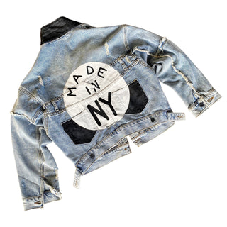 Lighter blue denim wash. White circle, painted MADE IN NYC inside in black.  Pockets and hems painted black Signed @wrenandglory.