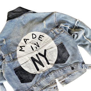 Lighter blue denim wash. White circle, painted MADE IN NYC inside in black.  Pockets and hems painted black Signed @wrenandglory.